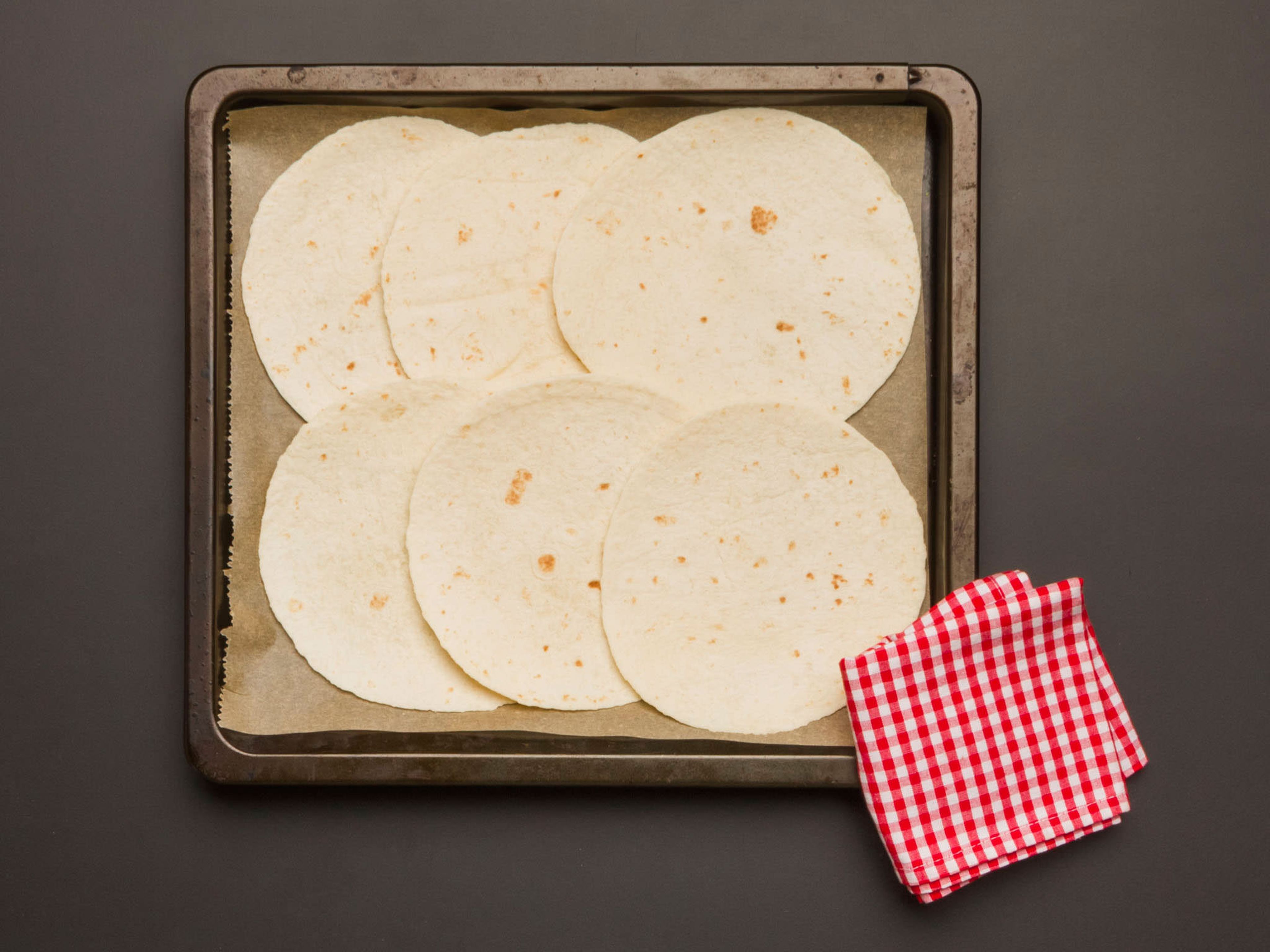 Tortillas auf eine glatte Arbeitsfläche legen. Mit Avocadocreme. Korianderreis, gewürfelten Tomaten, Austernseitlingen und Cheddar füllen.