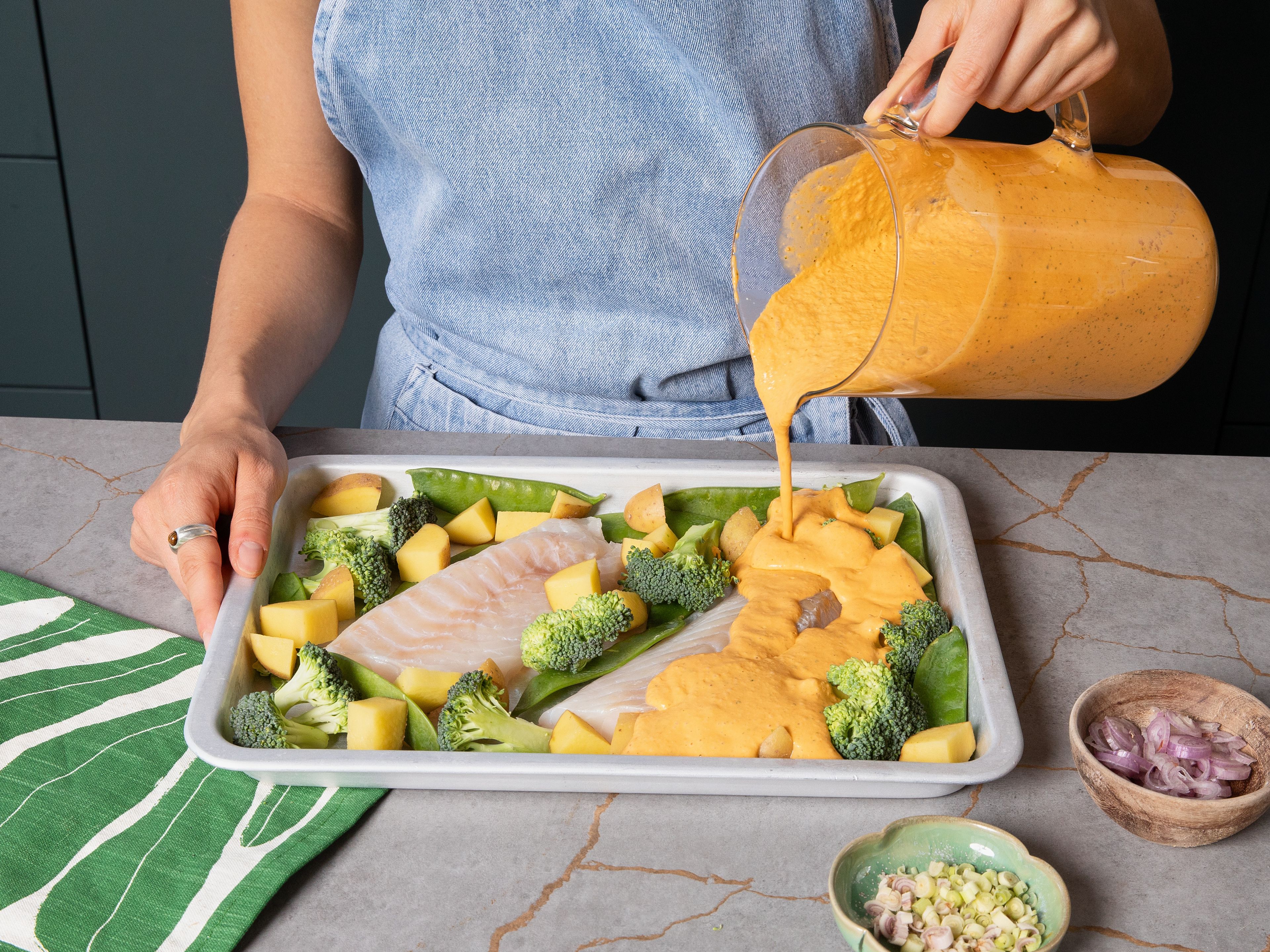 Für die Currysoße Currypaste mit Kokosmilch, Fischsauce, Limettensaft, Knoblauch, Ingwer, Koriander und Zucker in einem hohen Gefäß pürieren, bis eine glatte Soße entsteht. Nach Belieben mit Salz und Pfeffer abschmecken. Fischfilets auf das Backblech legen und Brokkoli, Kartoffeln und Zuckerschoten drumherum verteilen. Zitronengras und Zwiebeln darüberstreuen und alles mit der Currysoße übergießen.