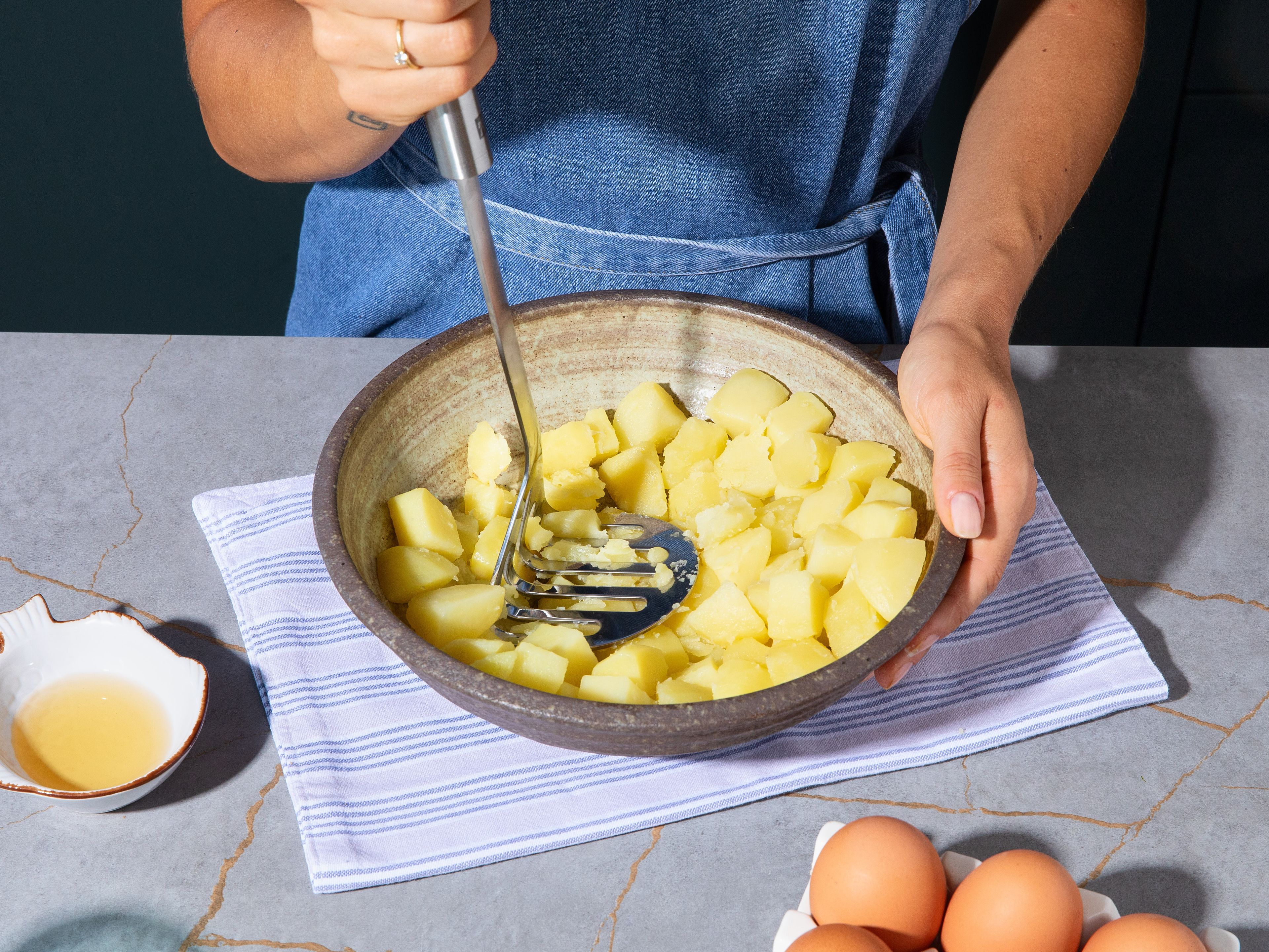 Peel potatoes and cut into rough cubes. Add to a pot of cold, generously salted water and cook for approx. 15 min., until tender. Drain and let potatoes steam dry over medium heat until the remaining moisture has evaporated, occasionally shaking the pot. Roughly mash potatoes with a potato masher, stir in rice vinegar and let cool completely.