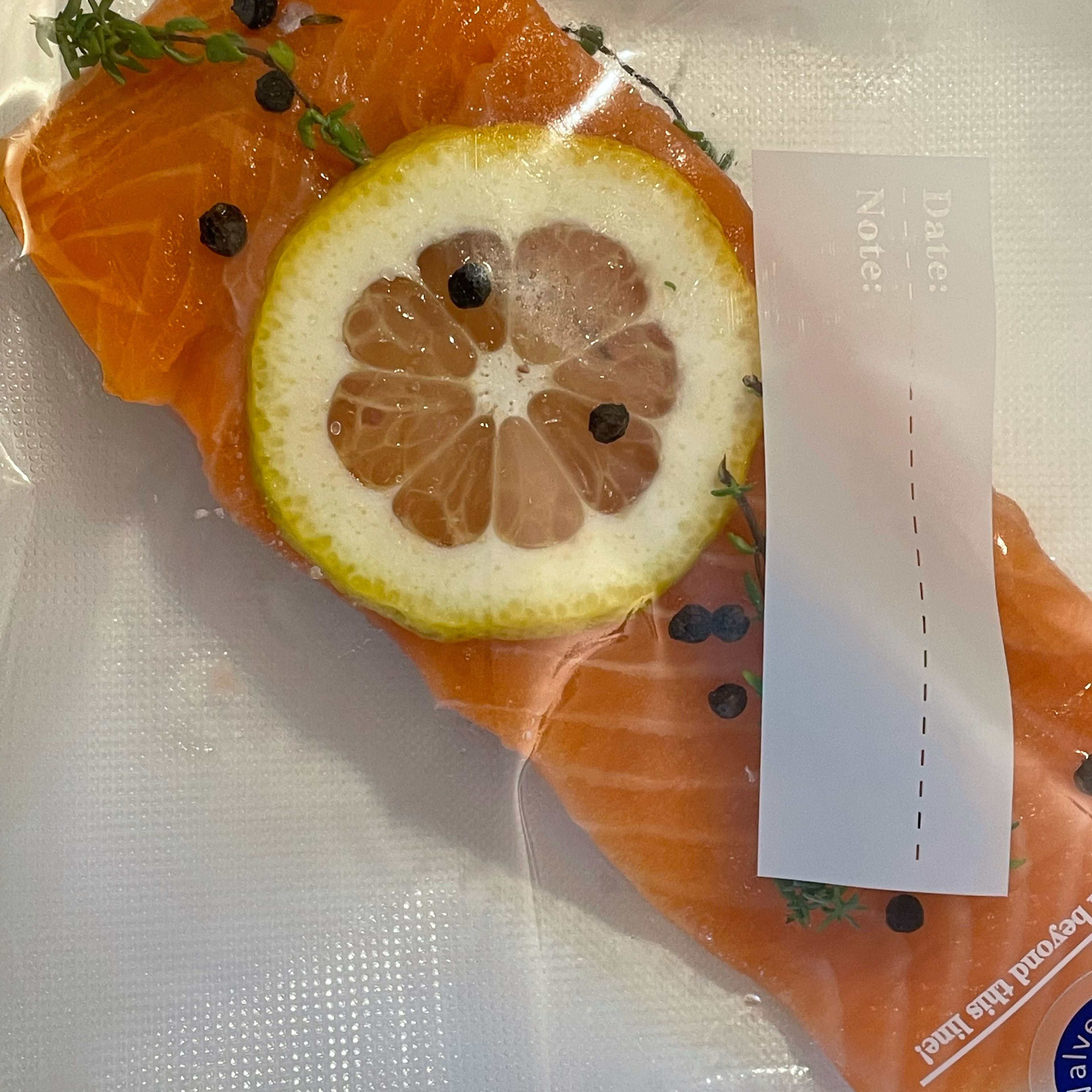 Lachs waschen, Schuppen entfernen, Haut einritzen und in zwei Portionen teilen. Zitrone waschen und in 2-3 mm dicke Scheiben schneiden. Je 1 Stück Lachs mit einer Scheibe Zitrone, einem 1/2 Zweig Thymian und 1/2 TL Pfefferkörner im Sous Vide Beutel vakuumieren.