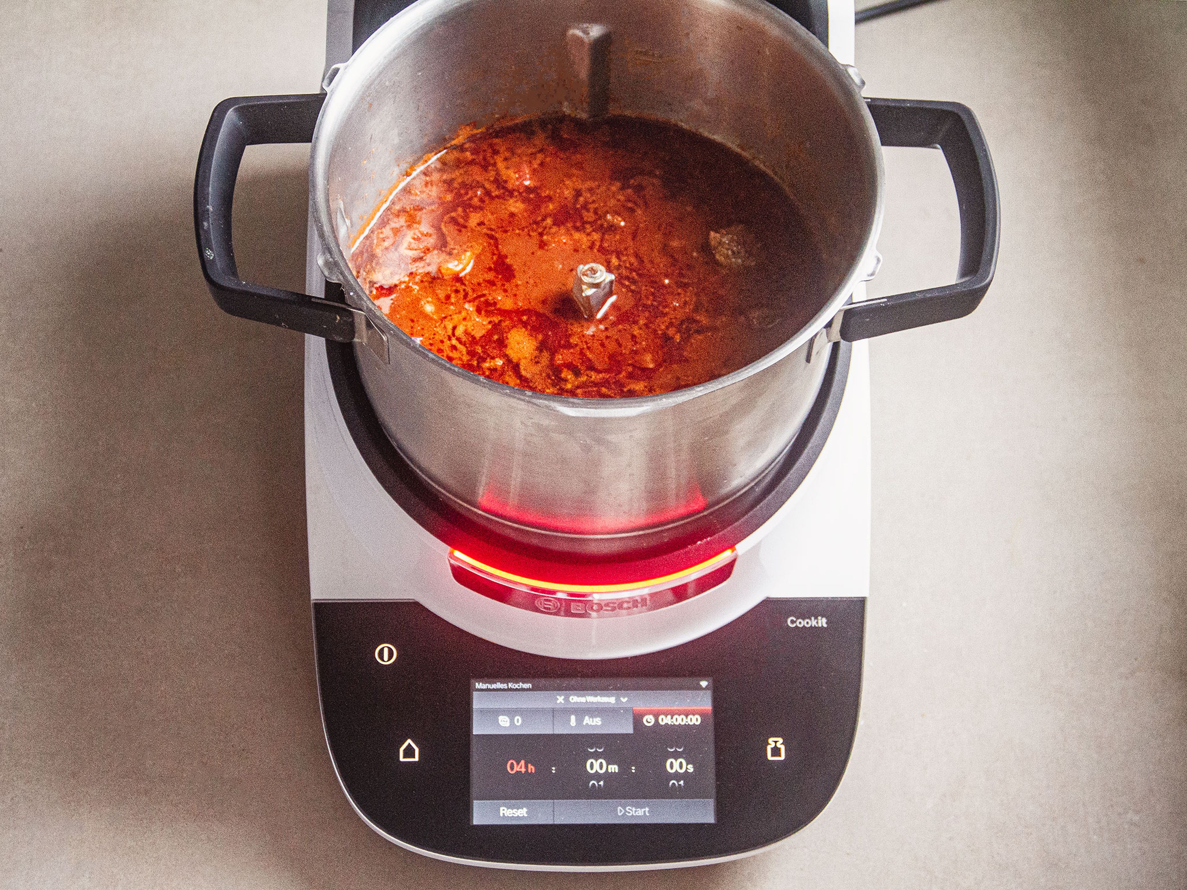 Anschließend 50 ml Öl in den Topf geben, den 3D-Rührer einsetzen, den Deckel schließen und den Messbecher einsetzen. Die Zwiebeln und den Knoblauch anbraten (3D-Rührer, Stufe 5, 130°C, 10 Min.). Das Paprikapulver und das Tomatenmark in den Topf geben und anschwitzen (3D-Rührer, Stufe 5, 130°C, 3 Min.). Dann das Fleisch und alle weiteren  Zutaten, bis auf die Bohnen, den Limettensaft und -abrieb, in den Topf geben und bei geschlossenem Deckel und mit dem eingesetzten Messbecher köcheln lassen (3D-Rührer, Stufe 3, 99°C, 7 Min.).  Anschließen für weitere ca. 3,5 Std. schmoren lassen (Stufe 2, 99°C, 210 Min.). Dann den 3D-Rührer entnehmen.