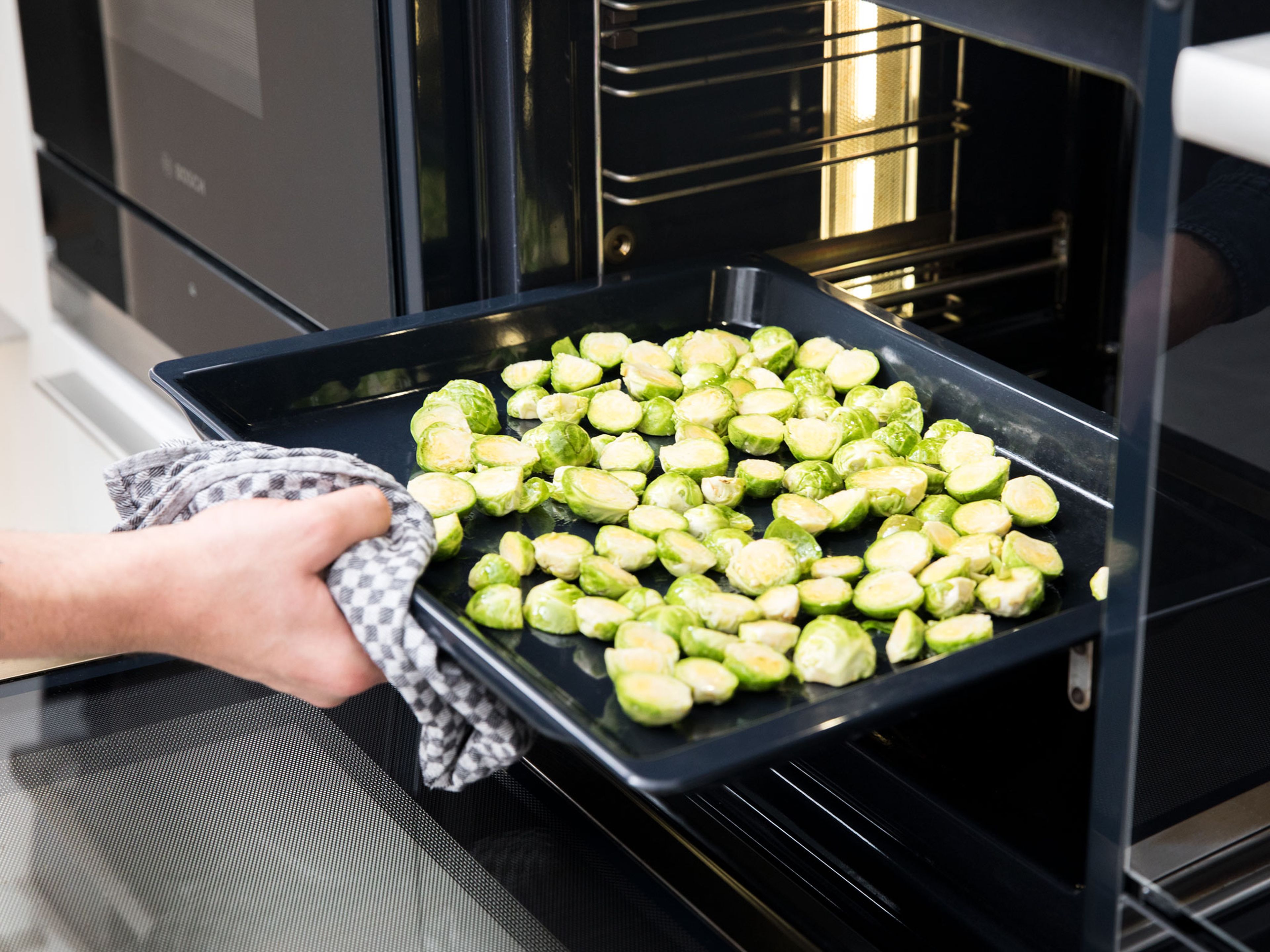 Preheat oven to 220°C/430°F. Halve Brussels sprouts and add to a bowl. Add most of the sesame oil, season with salt, and stir to combine. Transfer to a baking sheet and bake for approx. 20 min.