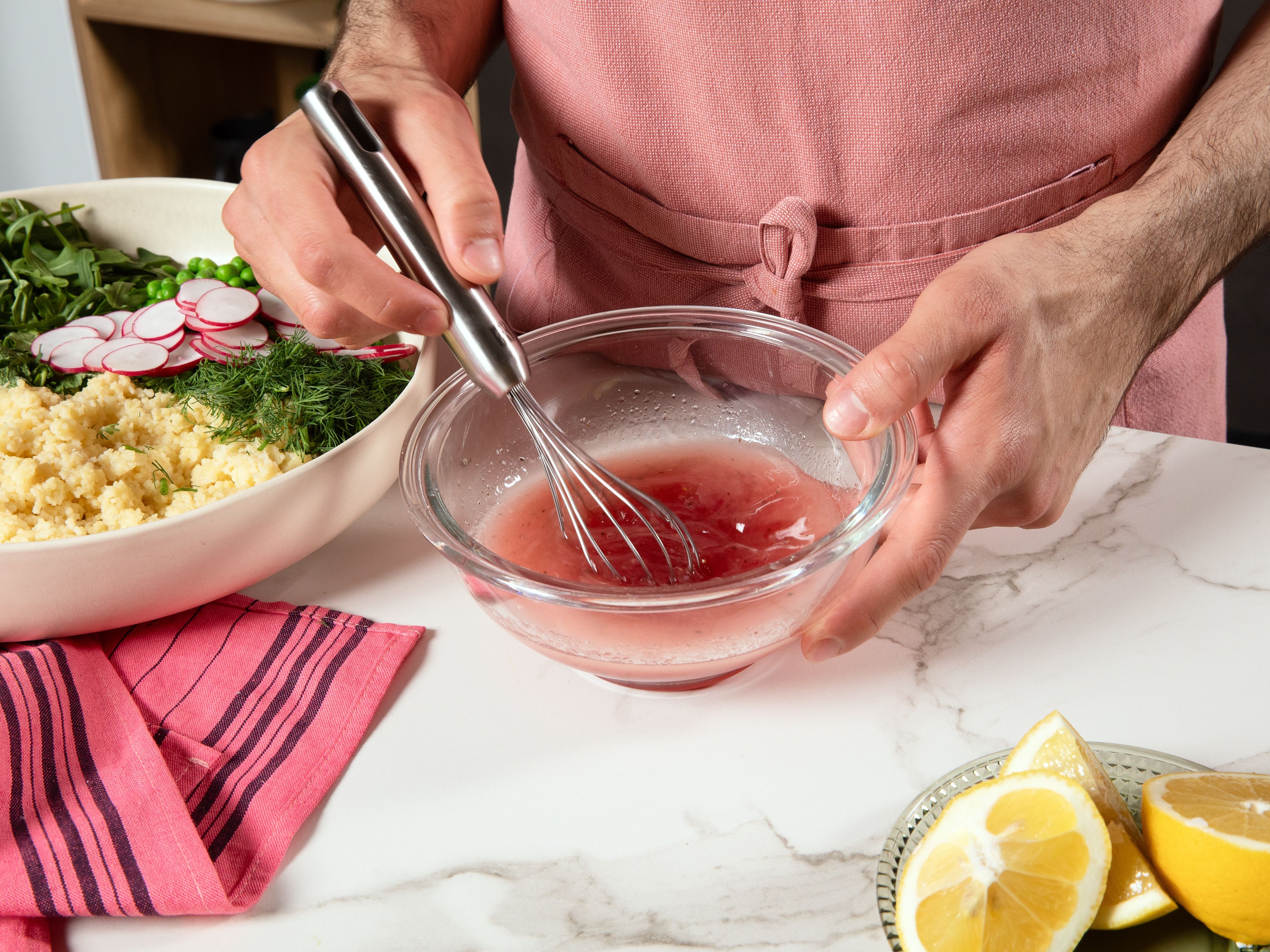Für das Dressing Zitronensaft, Himbeeressig, Olivenöl und Agavendicksaft in einer Schüssel verrühren. Mit Salz und Pfeffer abschmecken. Dressing über den Couscous geben und alles vorsichtig vermengen. Mit zerbröseltem Feta toppen und vor dem Servieren nach Geschmack mit mehr Salz und Pfeffer würzen.