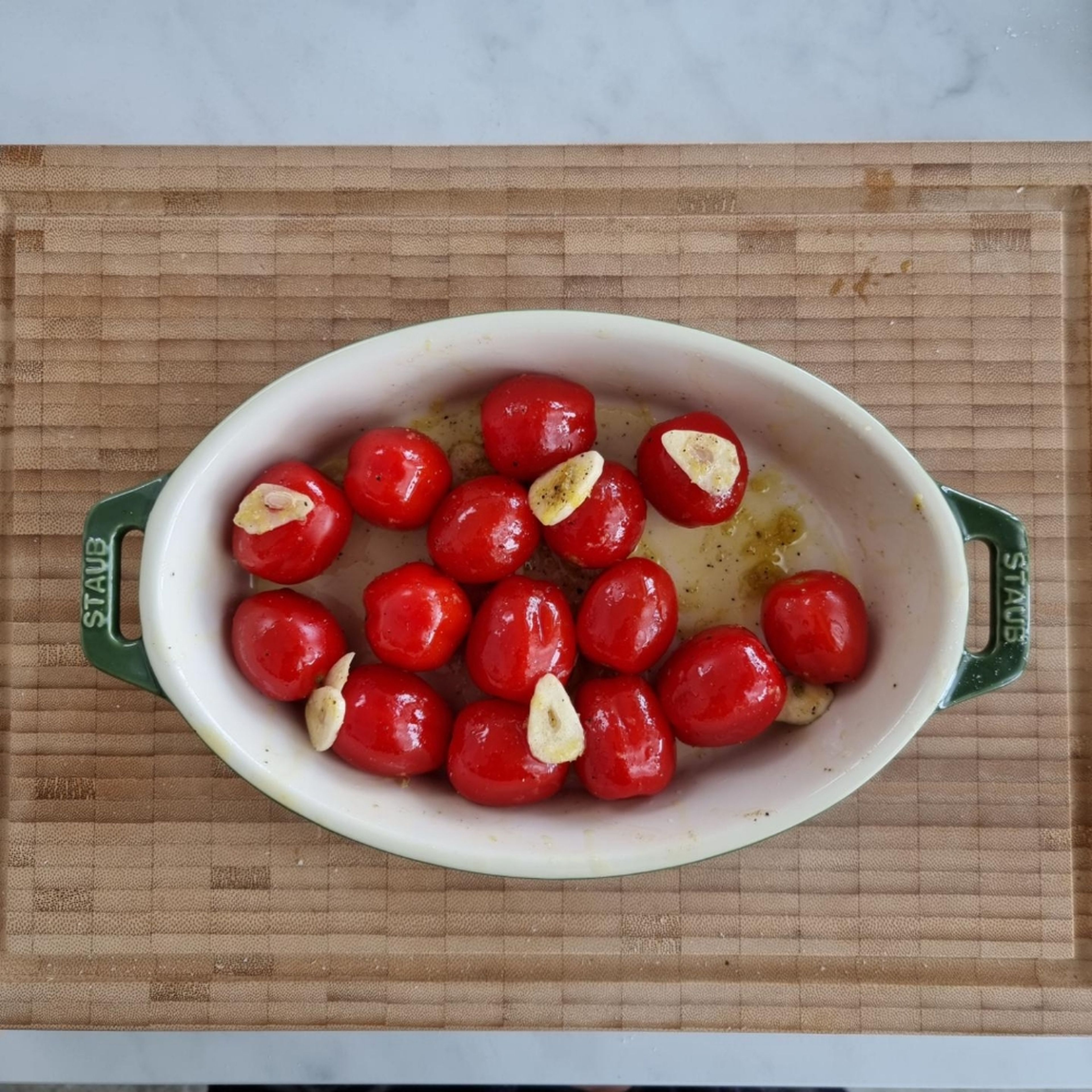 Combine the cherry tomatoes, some of the olive oil, lemon zest, half of the sliced garlic, a pinch of sugar, salt and pepper in a baking dish. Bake the tomatoes in the oven for approx. 12 min. Cook the pasta according to package directions.