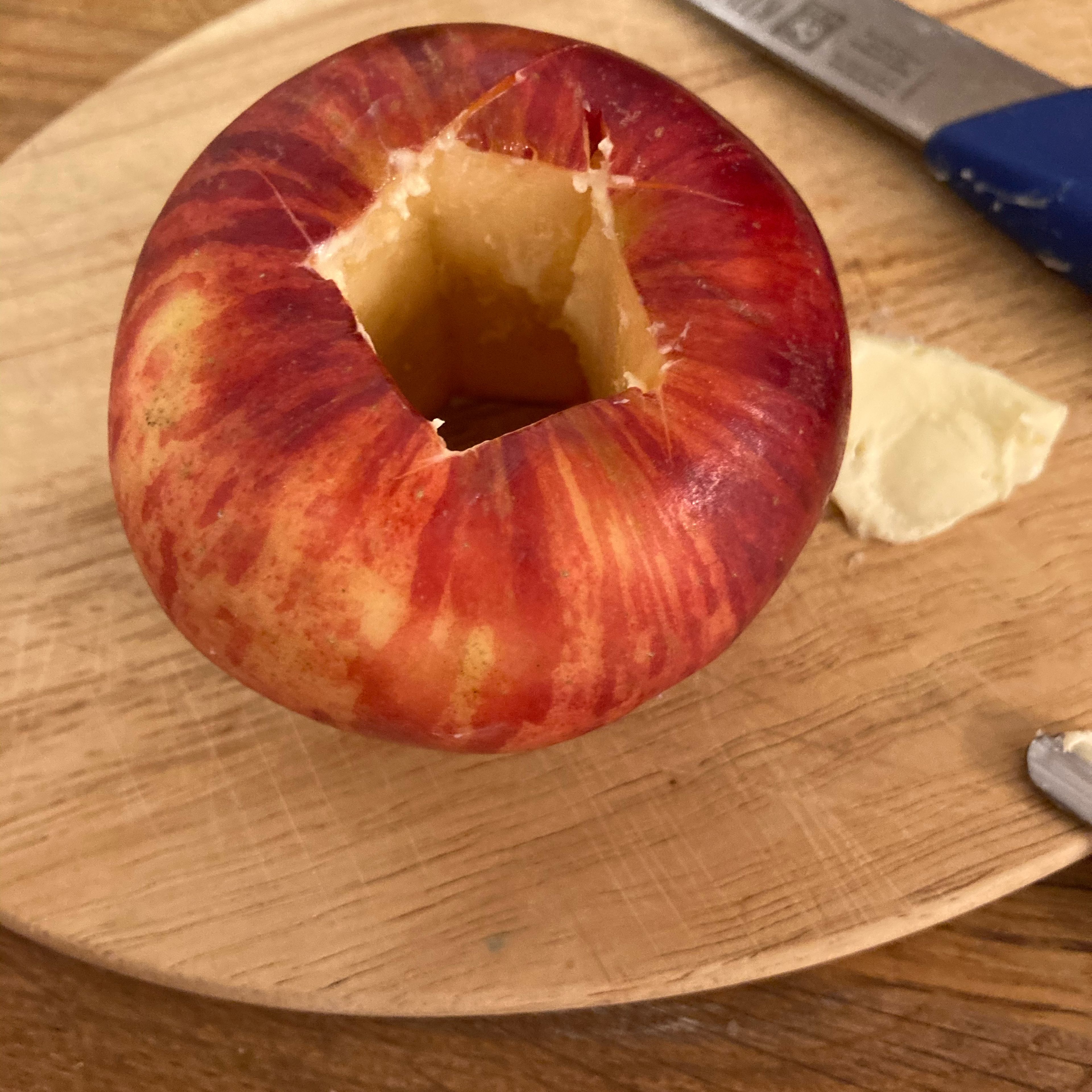 Loch im Apfel mit Butter aus schmieren