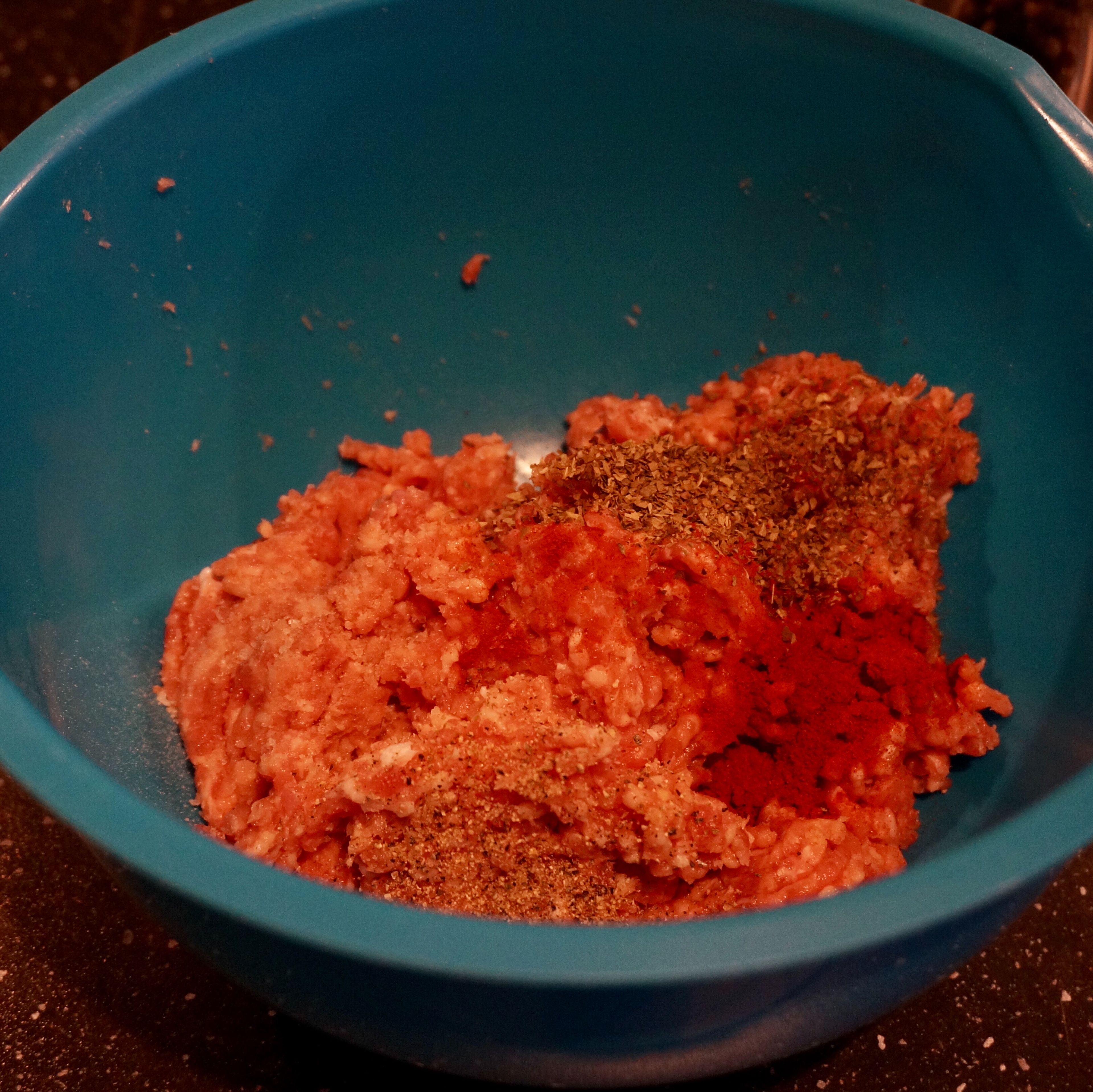 Add dried basil, paprika, salt, pepper to the minced meat. Mix everything thoroughly and add to the saucepan. Simmer for about 5 minutes