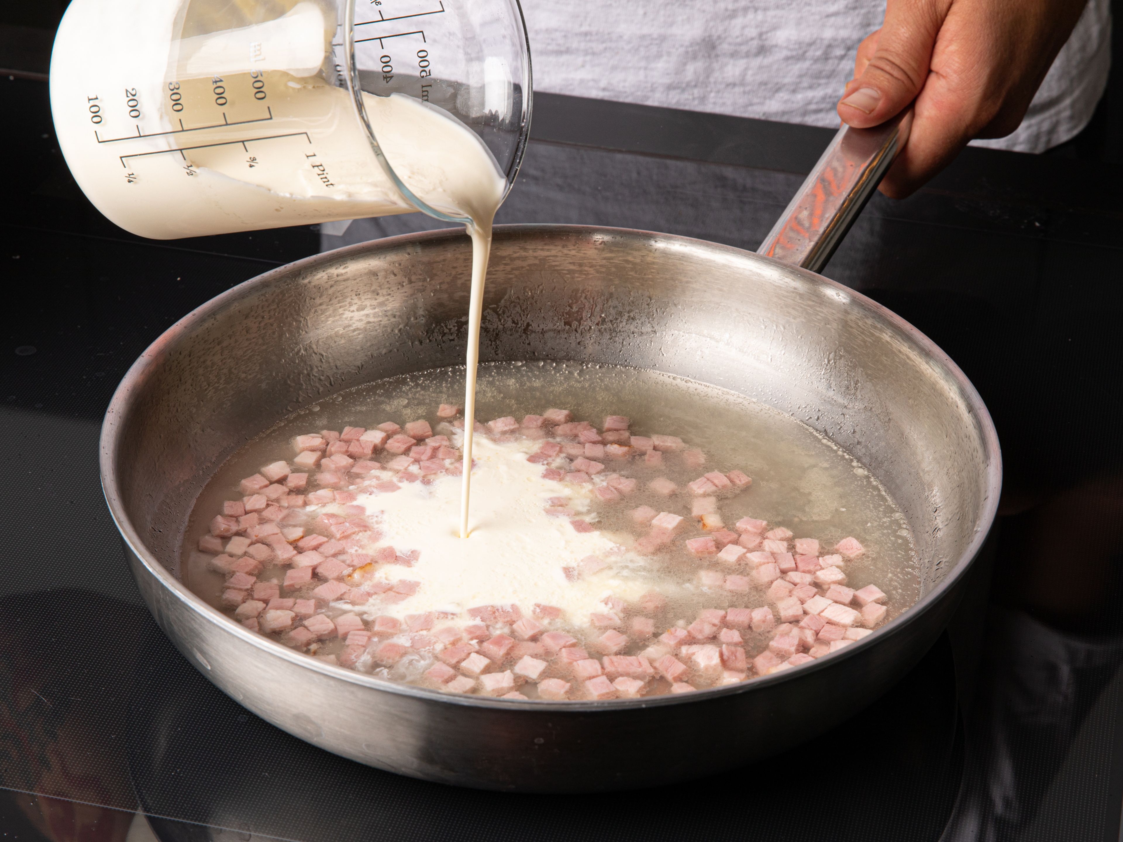 In a large frying pan, add oil and diced ham. Fry briefly, then deglaze with vegetable stock and cream and let simmer for approx. 5 min.