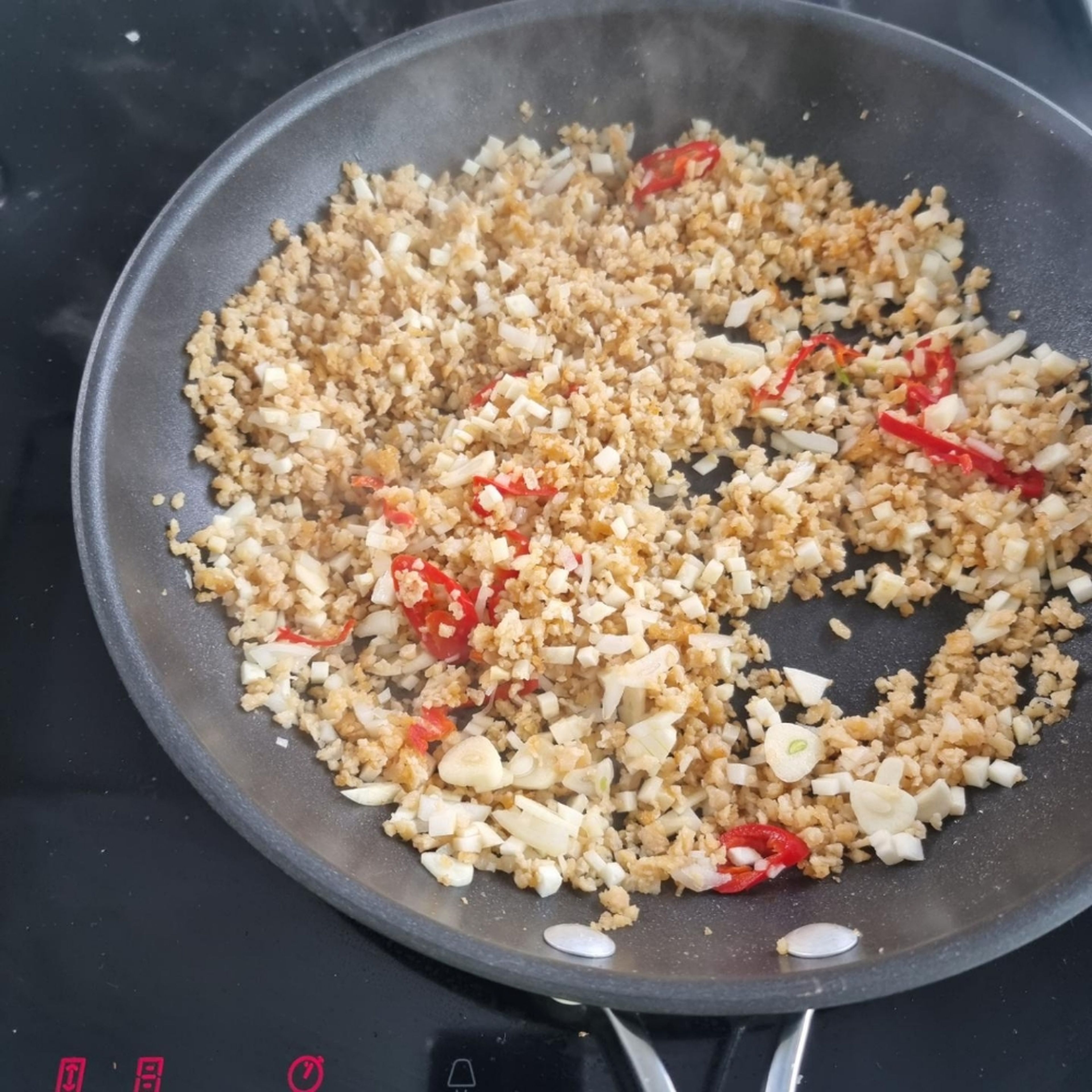 Fry the soy granules with the olive oil in a pan. Then add the cubed vegetables, the fennel seeds and the chili. Sauté until everything is well browned, add the tomato paste and mustard and sauté briefly.