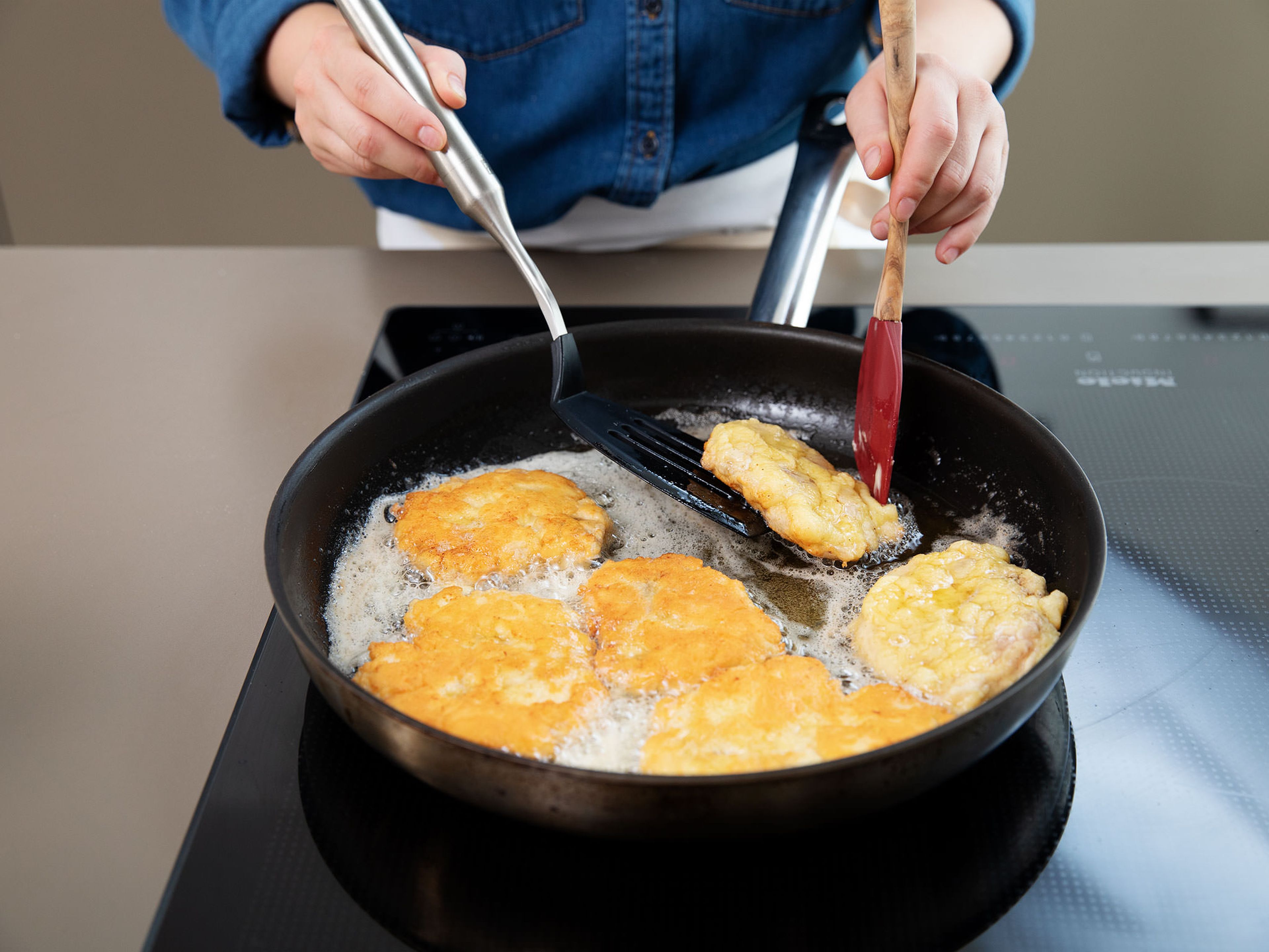 Pflanzenöl in einer Pfanne erhitzen. Butter dazugeben und Hähnchenschnitzel darin für ca. 2 - 3 Min. knusprig und goldbraun braten. Auf einem Küchenpapier abtropfen lassen.