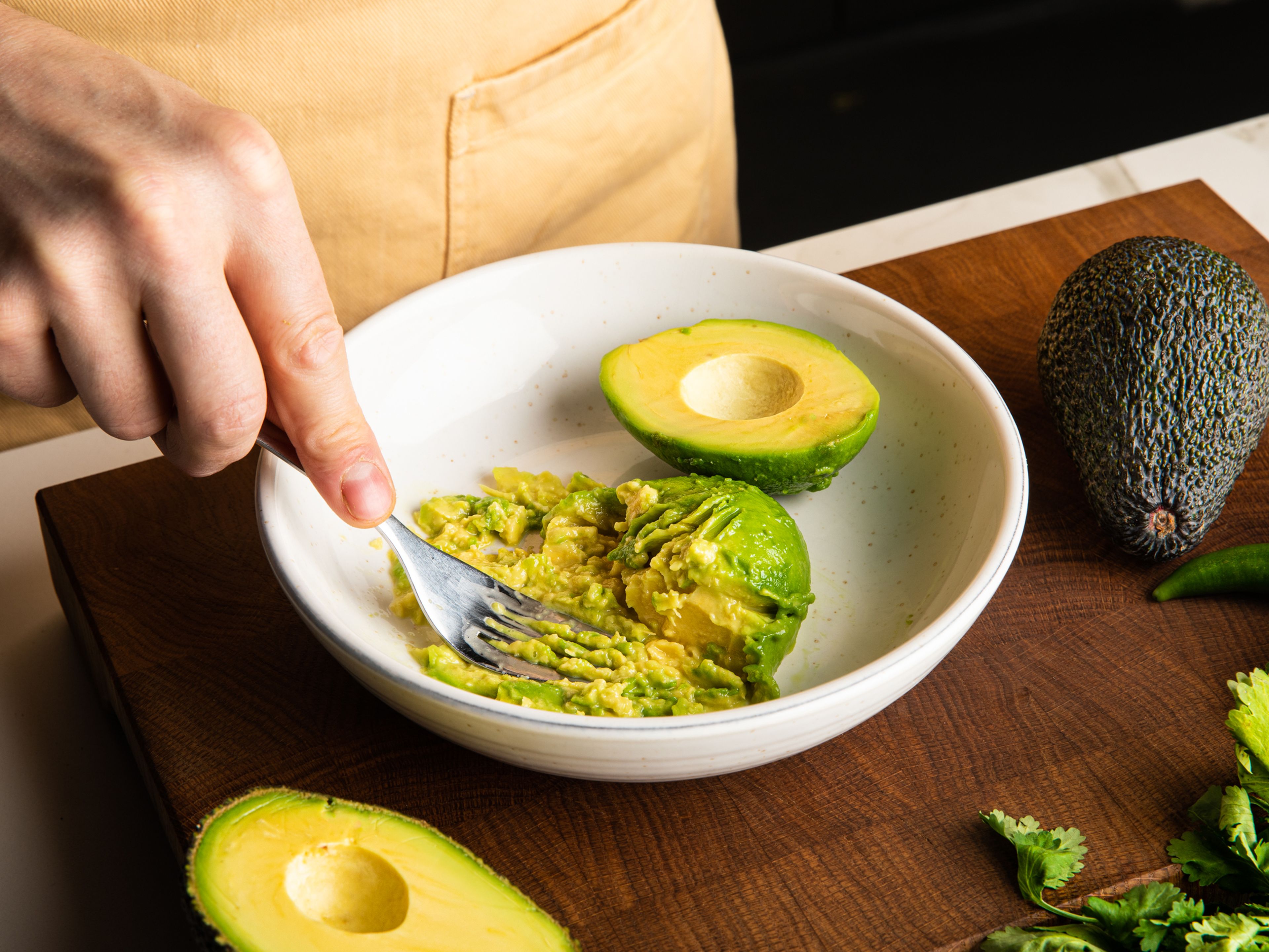 Halve the avocados, remove the pits and scoop out the avocado flesh into a mixing bowl.