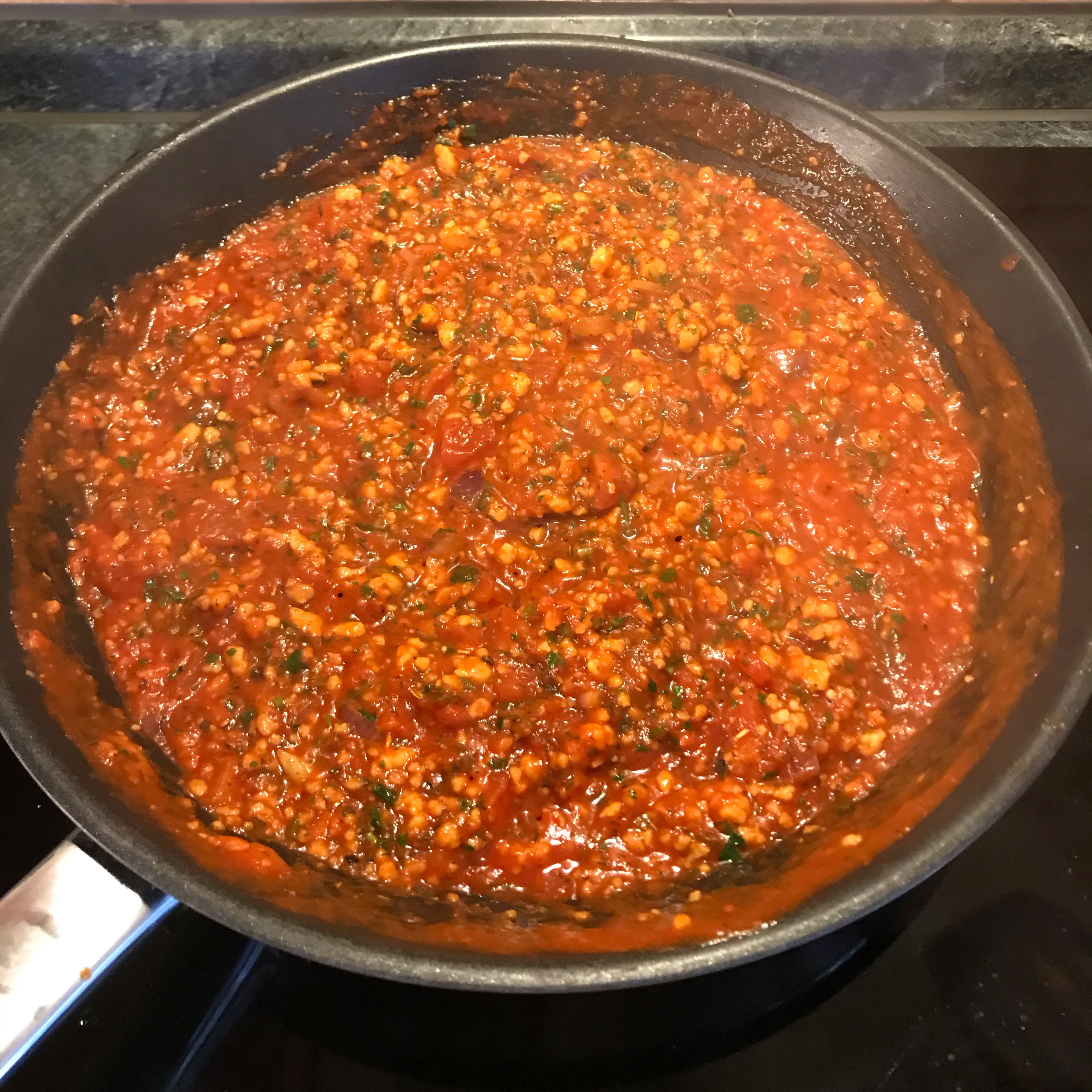 Mit den stückigen Tomaten ablöschen, umrühren und ca. 5 Minuten auf mittlerer Stufe vor sich hinköcheln lassen. Frische oder TK-Kräuter hinzufügen und nach Belieben abschmecken.