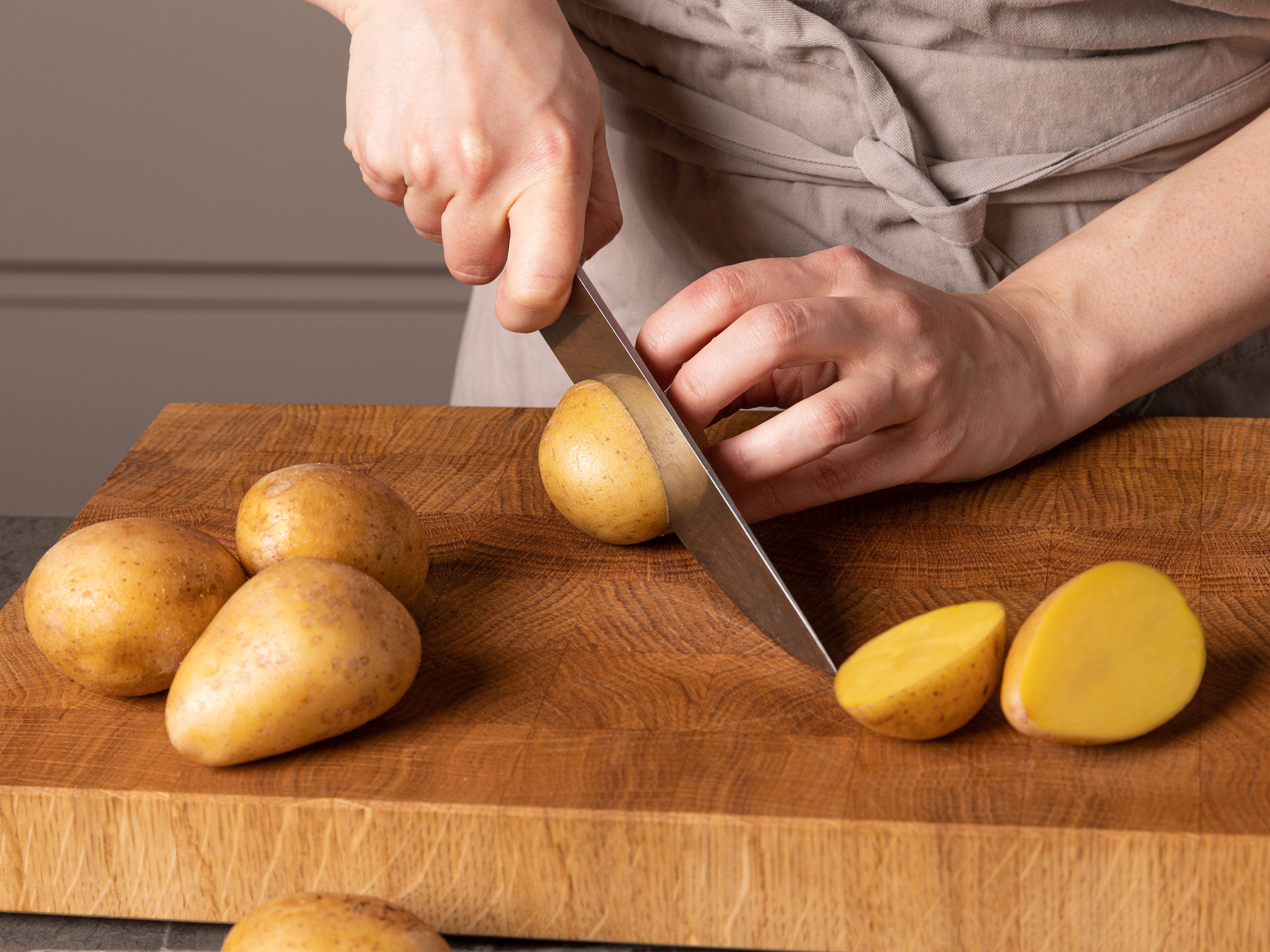 Die Auflaufform in den Ofen schieben und diesen auf 220°C vorheizen. In der Zwischenzeit die Kartoffeln halbieren. Die Bohnen aus der Dose abgießen und abspülen. Den Parmesankäse reiben. Bärlauch putzen. Zitrone abreiben und auspressen.