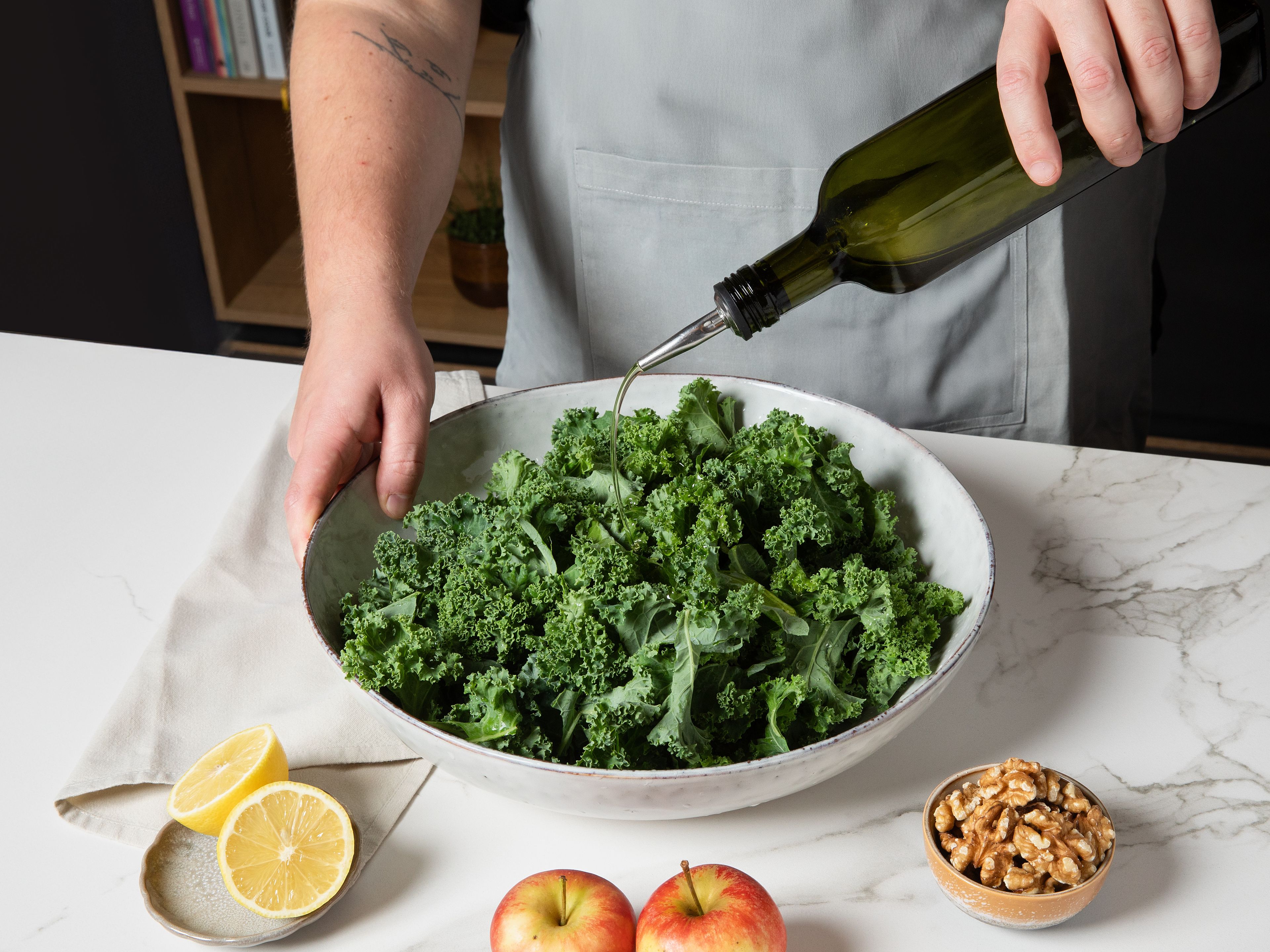 Den Grünkohl waschen, den Strunk entfernen und die Blätter in mundgerechte Stücke zupfen. Dann den Grünkohl in eine große Schale geben, mit einer Prise Salz und einem Teil des Olivenöls ca. 1–2 Min. leicht massieren, bis er weicher und dunkler wird. Baguette in kleine Würfel schneiden, in einer Pfanne mit etwas Olivenöl und einer Prise Salz goldbraun rösten.