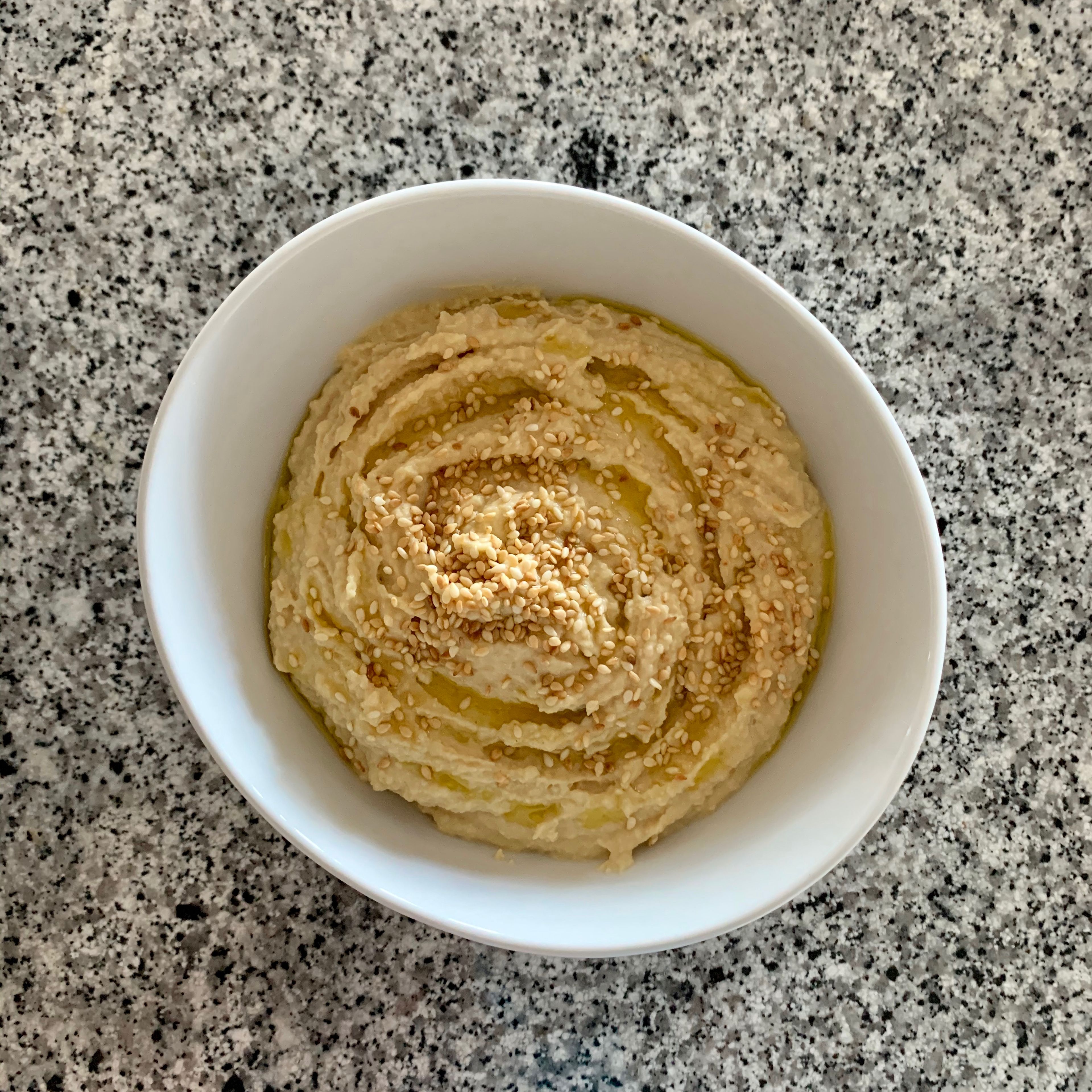 Transfer the hummus to a bowl, serve with a drizzle of olive oil and sprinkle with sesame seeds.