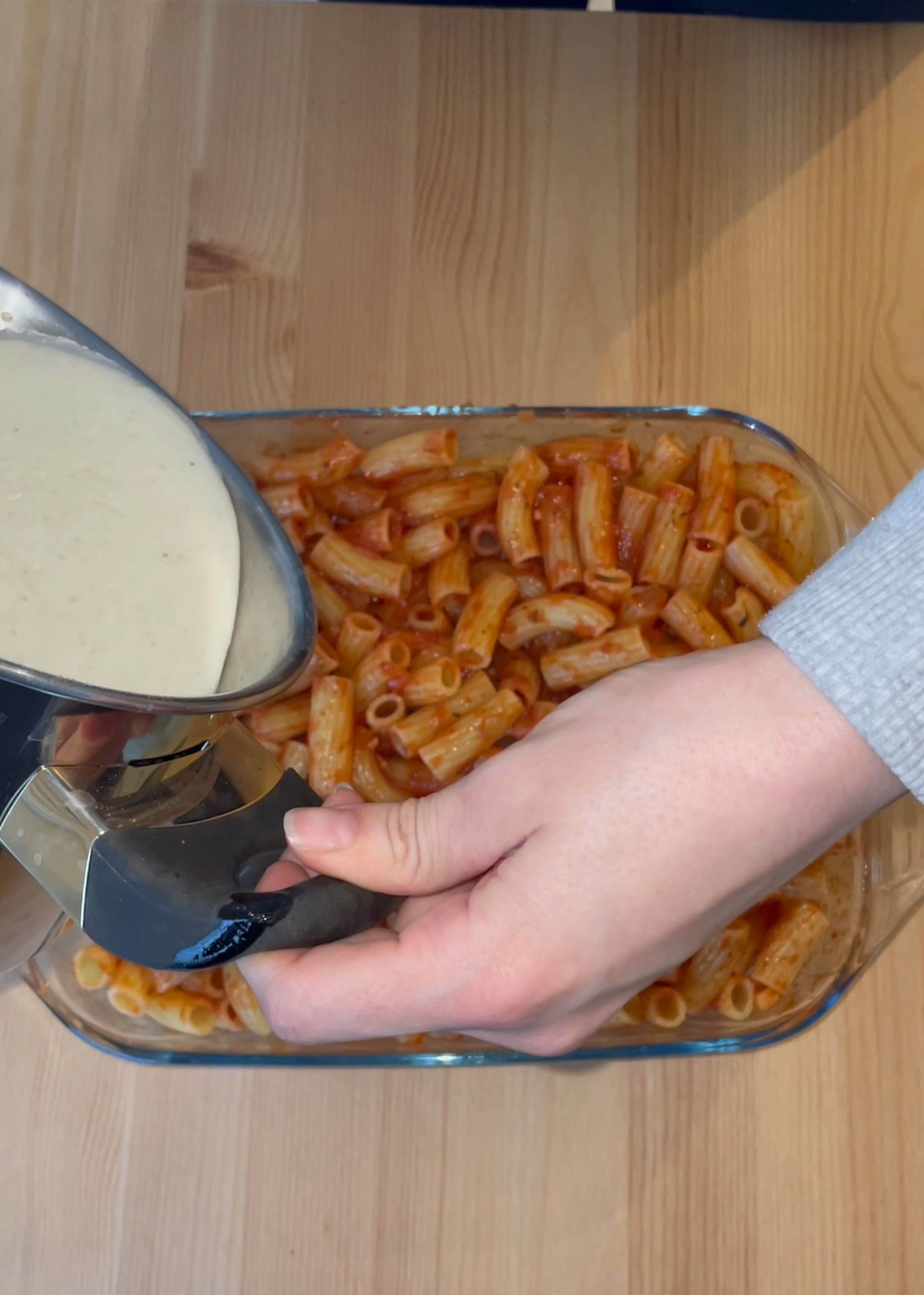 Die Nudeln in der Auflaufform gut mit der Tomatensauce vermengen. Daraufhin die Bechamelsauce darüber geben und gleichmäßig verteilen. Den Auflauf mit Käse bestücken und bei 190 Grad ca 20-25 Min in den Ofen geben, bis der Käse eine schöne Farbe hat.