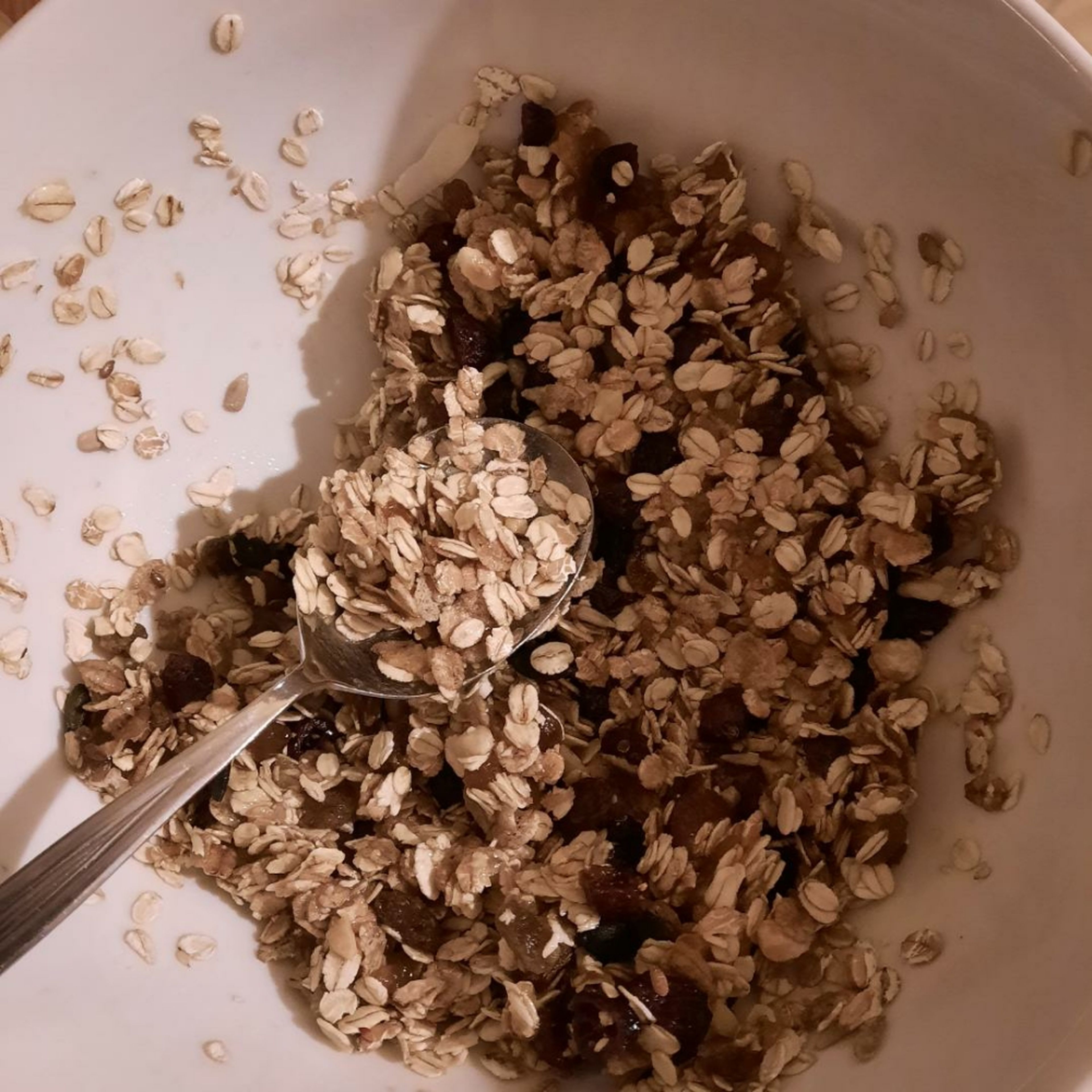 In einer Schüssel das Nussmüsli, die gemahlenen Mandeln, die Cranberries, die Aprikosen, den Honig und die Aprikosenkonfitüre vermischen.