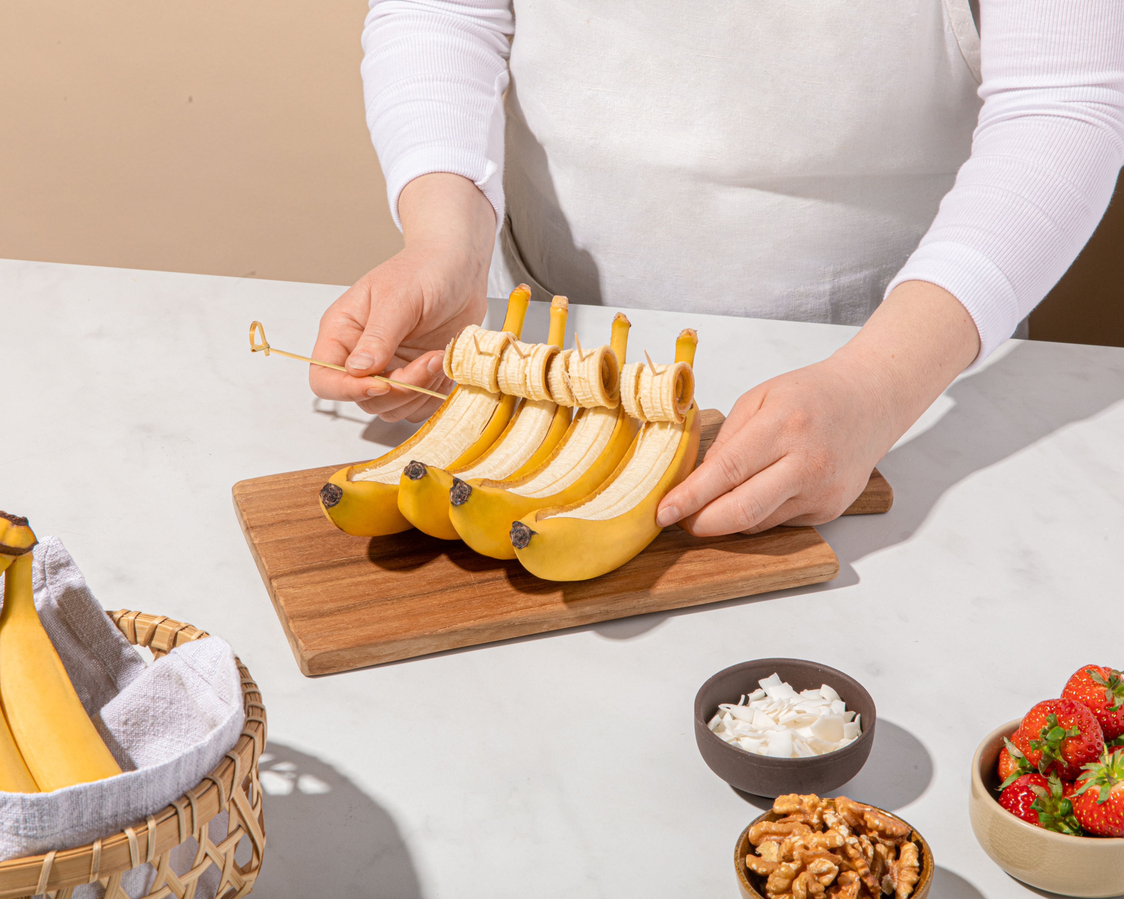 Die vier Bananen mit einem langen Schaschlikspieß fixieren, damit sie in der Grillpfanne nicht umkippen.