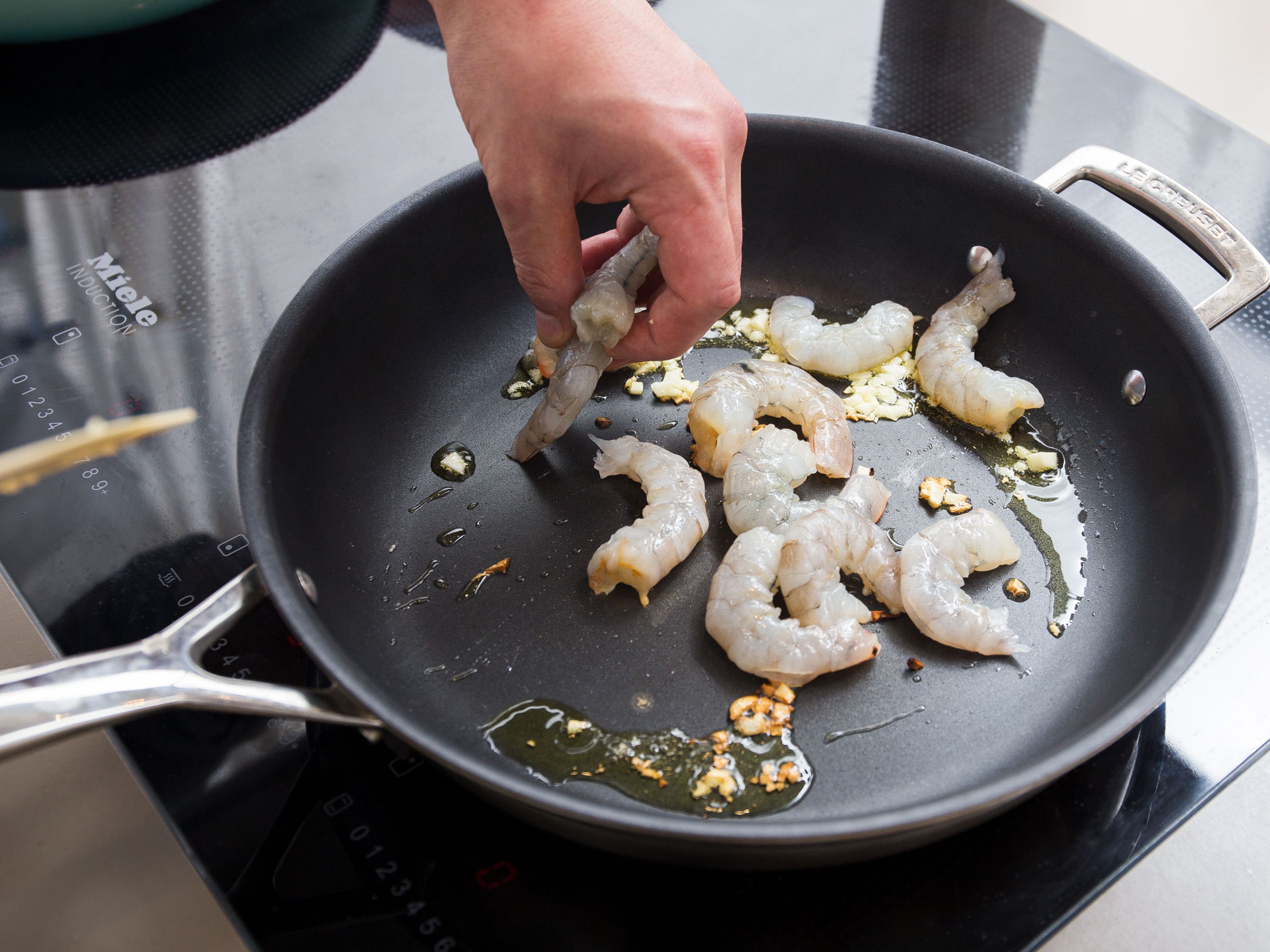 Heat oil in a a second frying pan over medium heat and fry remaining garlic for approx. 1 – 2 min. Add shrimp to pan and season with salt and pepper. Reduce heat to medium-low and fry shrimp on both sides for approx. 15 sec. Deglaze with lemon juice. Serve shrimp with coconut rice and baby bok choy. Enjoy!