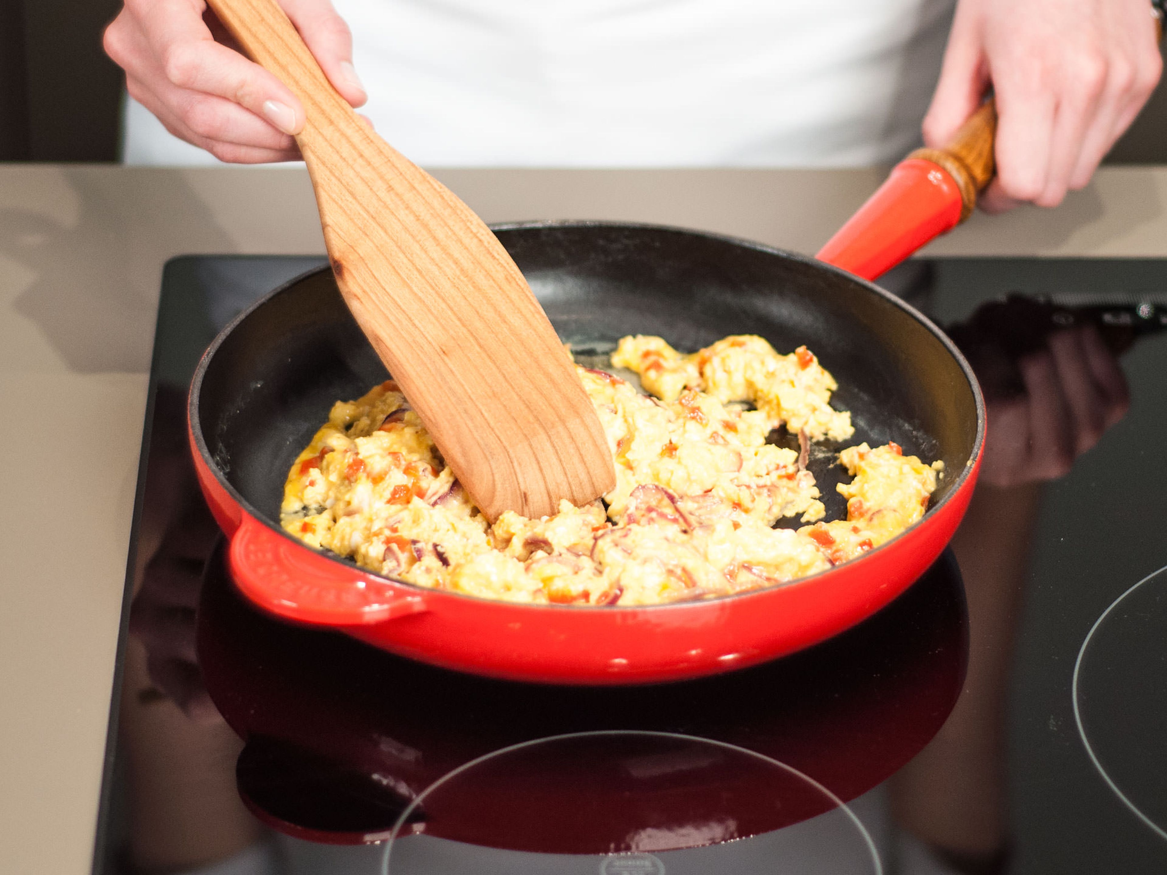 Eier in die Pfanne geben und weiter für ca. 3–5 Min. anbraten, gelegentlich umrühren. Käse zugeben und umrühren bis dieser geschmolzen ist.