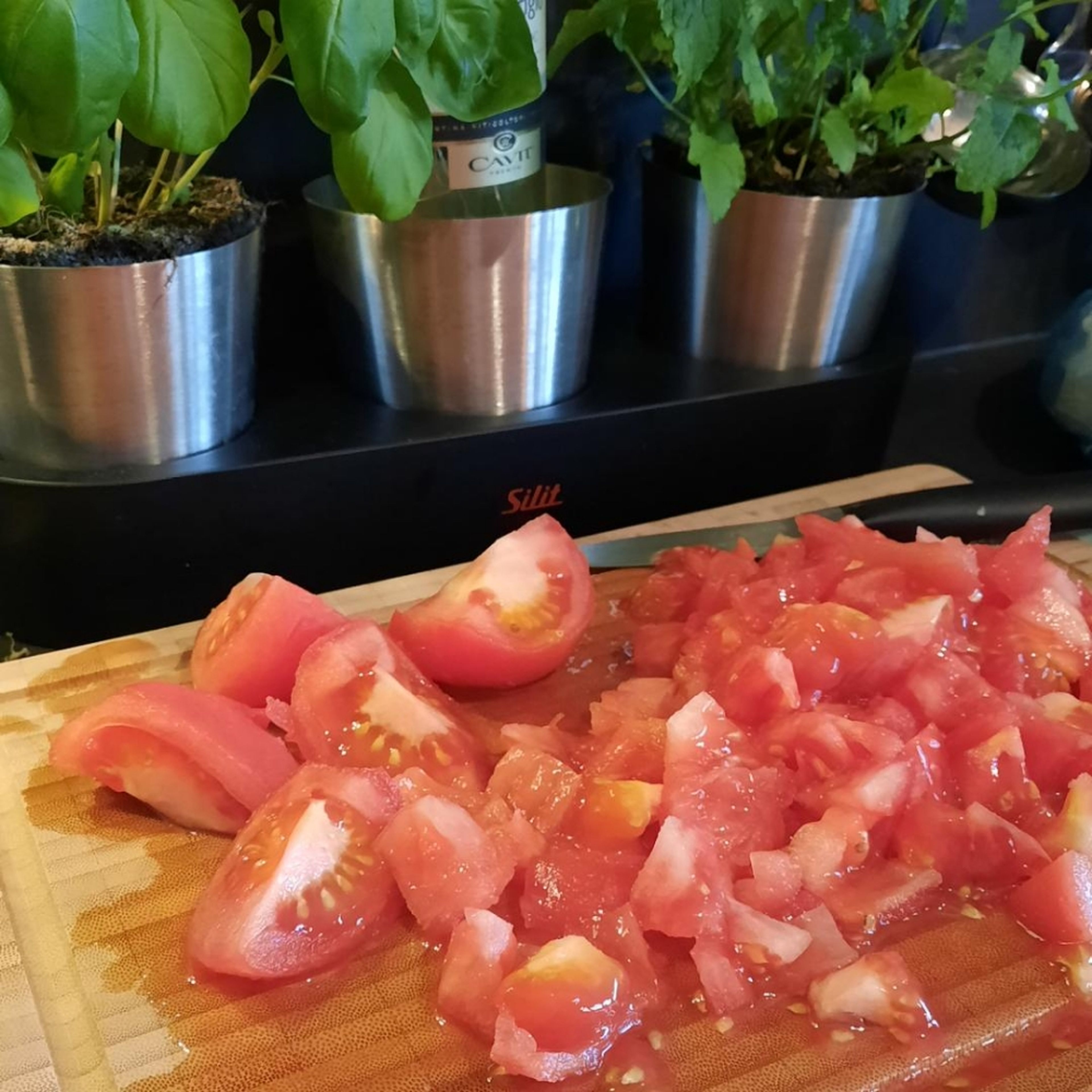 Die Tomaten würfeln und mit der Brühe in den Topf geben. Alles aufkochen und bei mittlerer Hitze ca. 10 Minuten köcheln lassen.