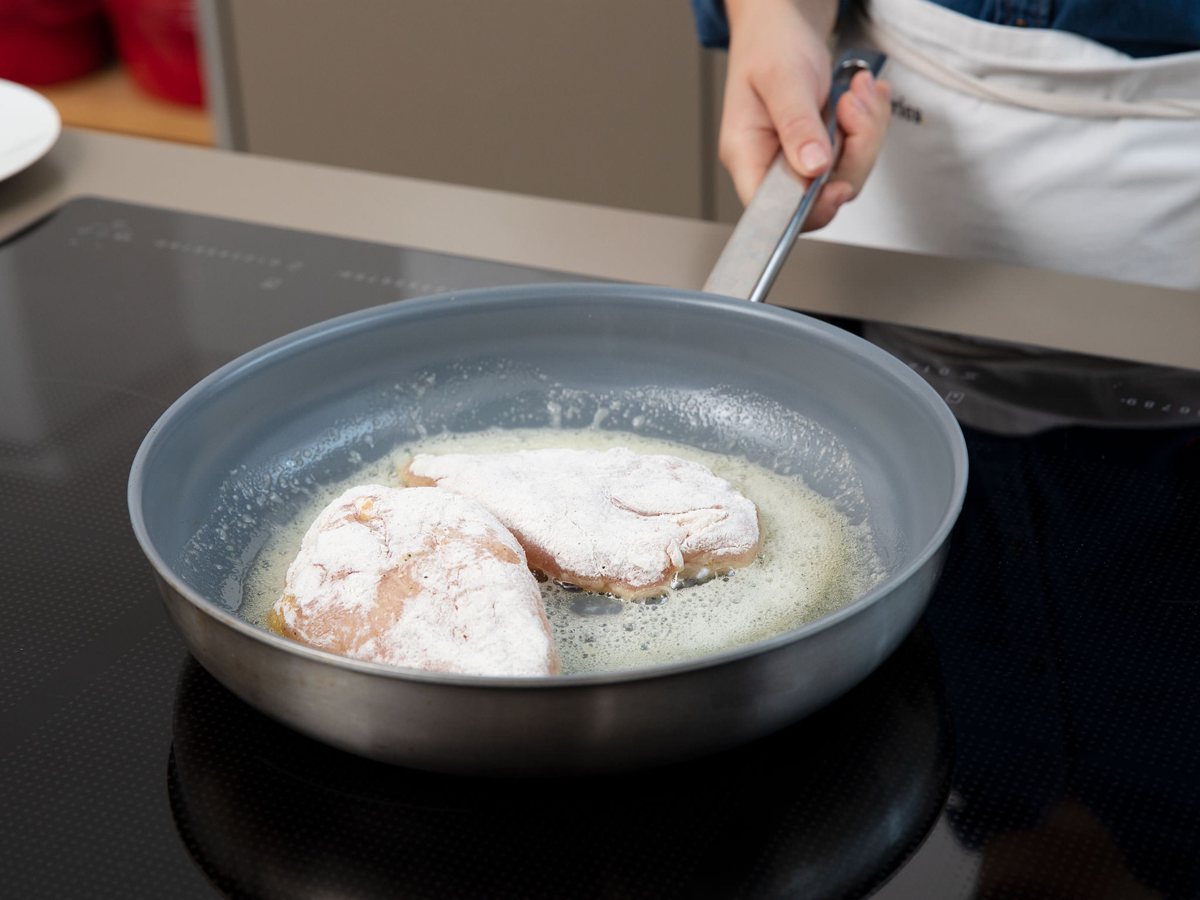 Heat butter in a frying pan set over medium-high heat. Fry chicken breasts for approx. 5 min., then flip and fry for another approx. 2 min. Remove chicken breasts from the frying pan. Add onion and garlic and fry until translucent.