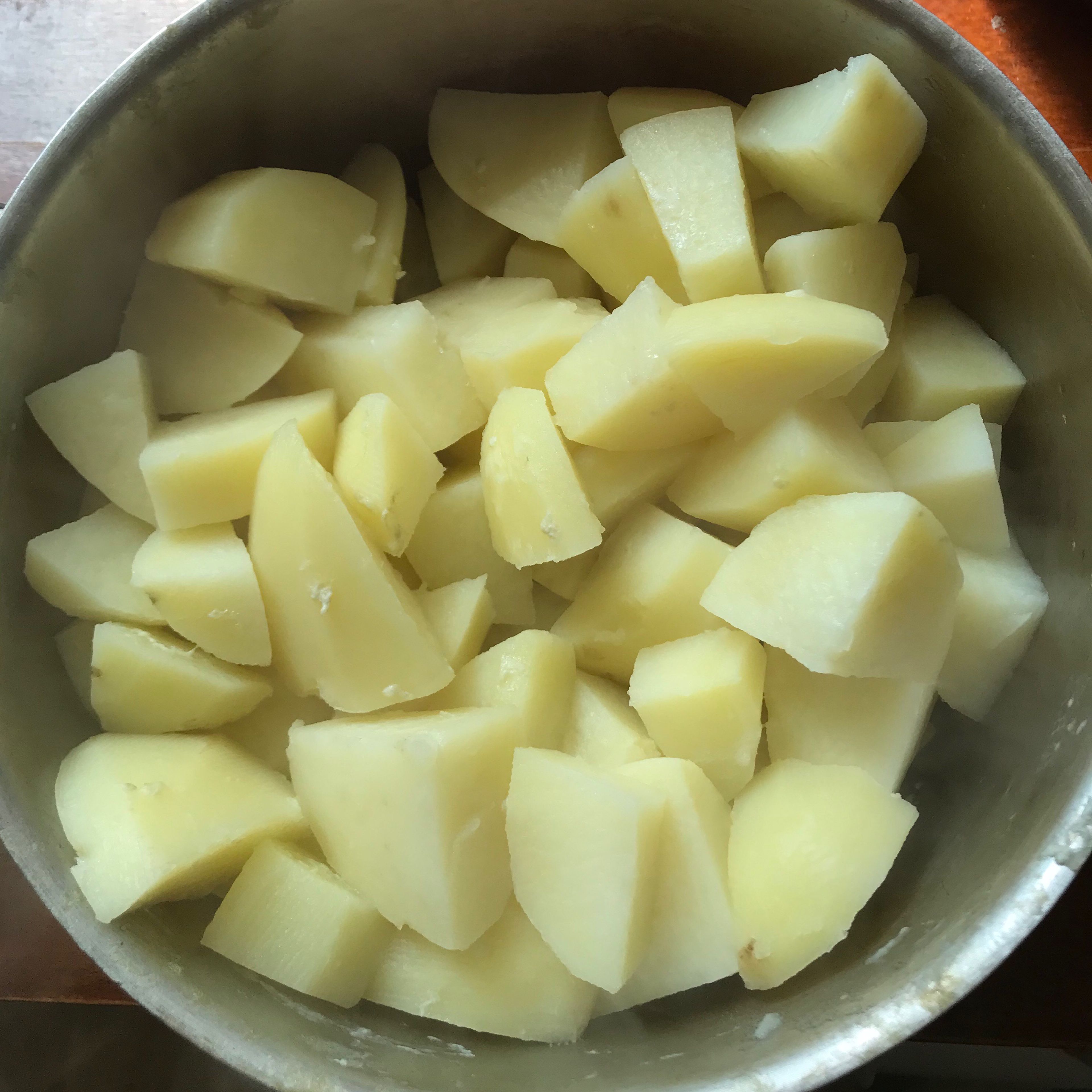 Peel, chop and boil the potatoes until soft, drain and mash with 50 g of the butter and 75ml milk and leave it to cool
