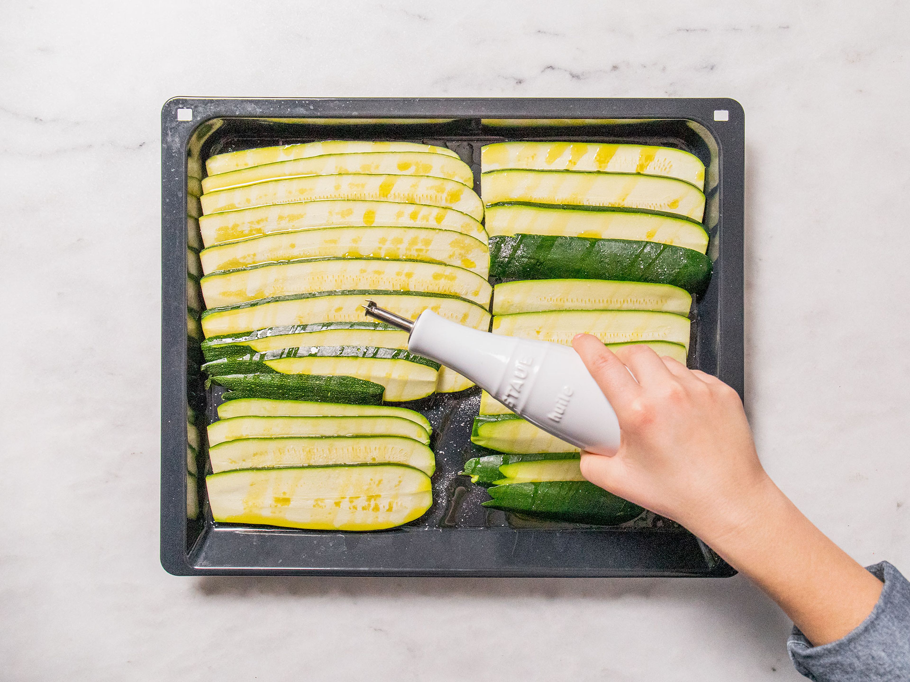 Layer zucchini slices onto a baking sheet and season with some salt. Drizzle with olive oil and bake for approx. 20 min.