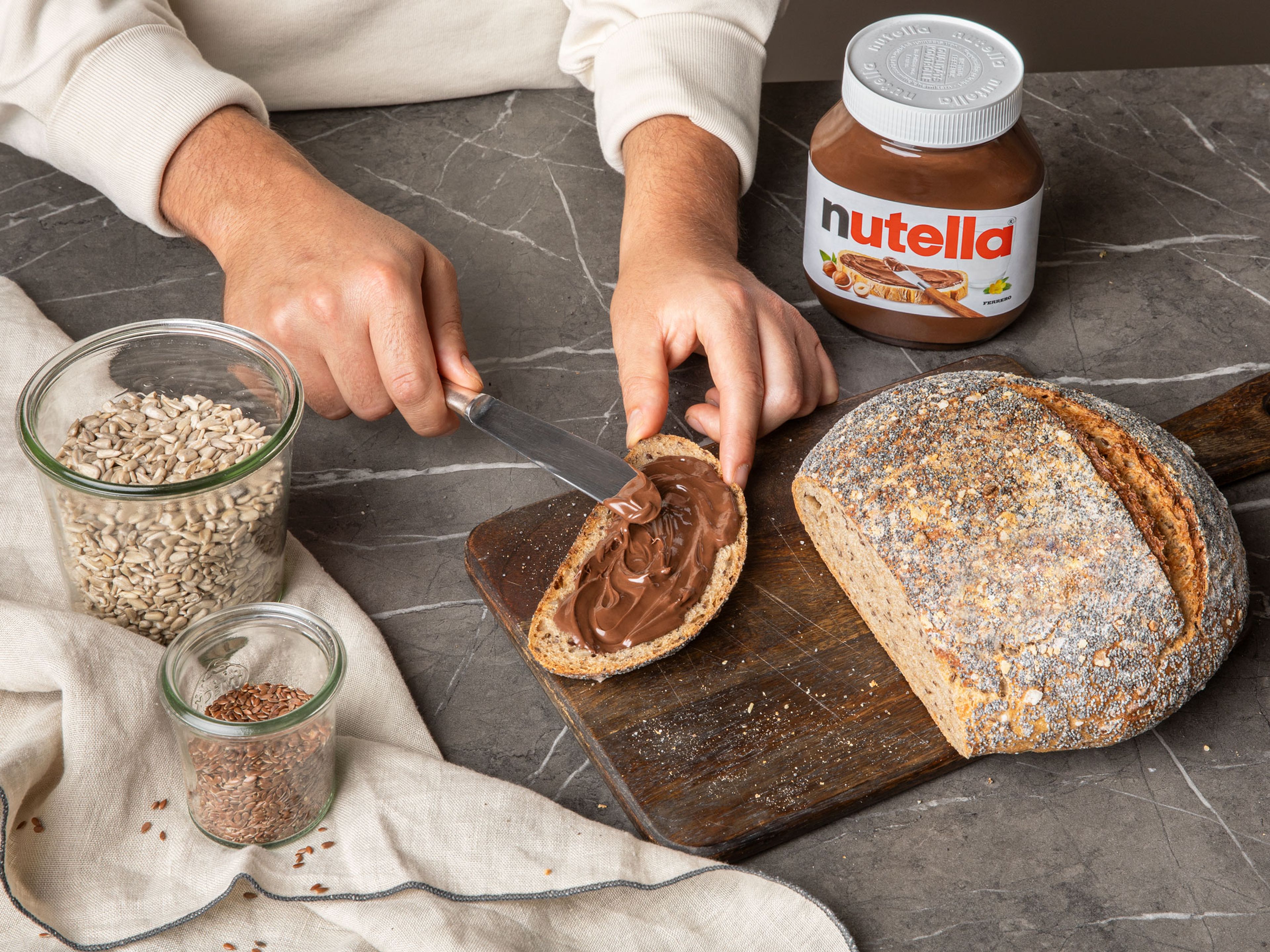 Sobald das Brot vollständig abgekühlt ist, in Scheiben schneiden und mit 15 g nutella® pro Portion bestreichen.