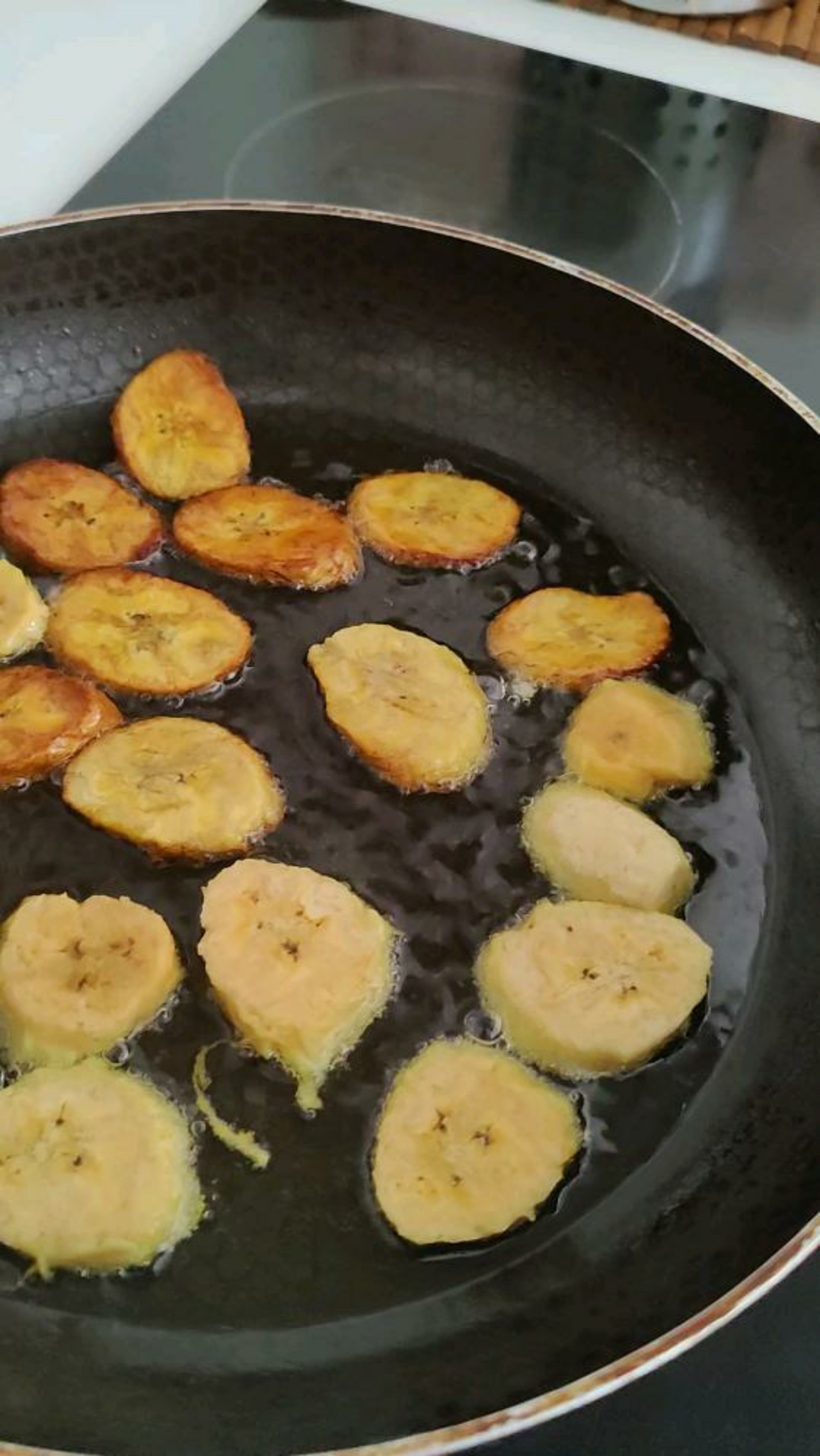 Fried Plantains Instructions: Cut each plantain in half then remove the peel. Then cut each plantain in slices half an inch or a little over a centimeter at slanted angles. Once all the plantain slices are ready, pour about half cup of frying oil into a pan and turn the stove to medium high heat (between 6 and 7 on an electric stove). If your heat is too high then reduce to medium, plantains can cook fast. Tip: To reduce the amount of trans fats released, you can substitute for coconut oil.