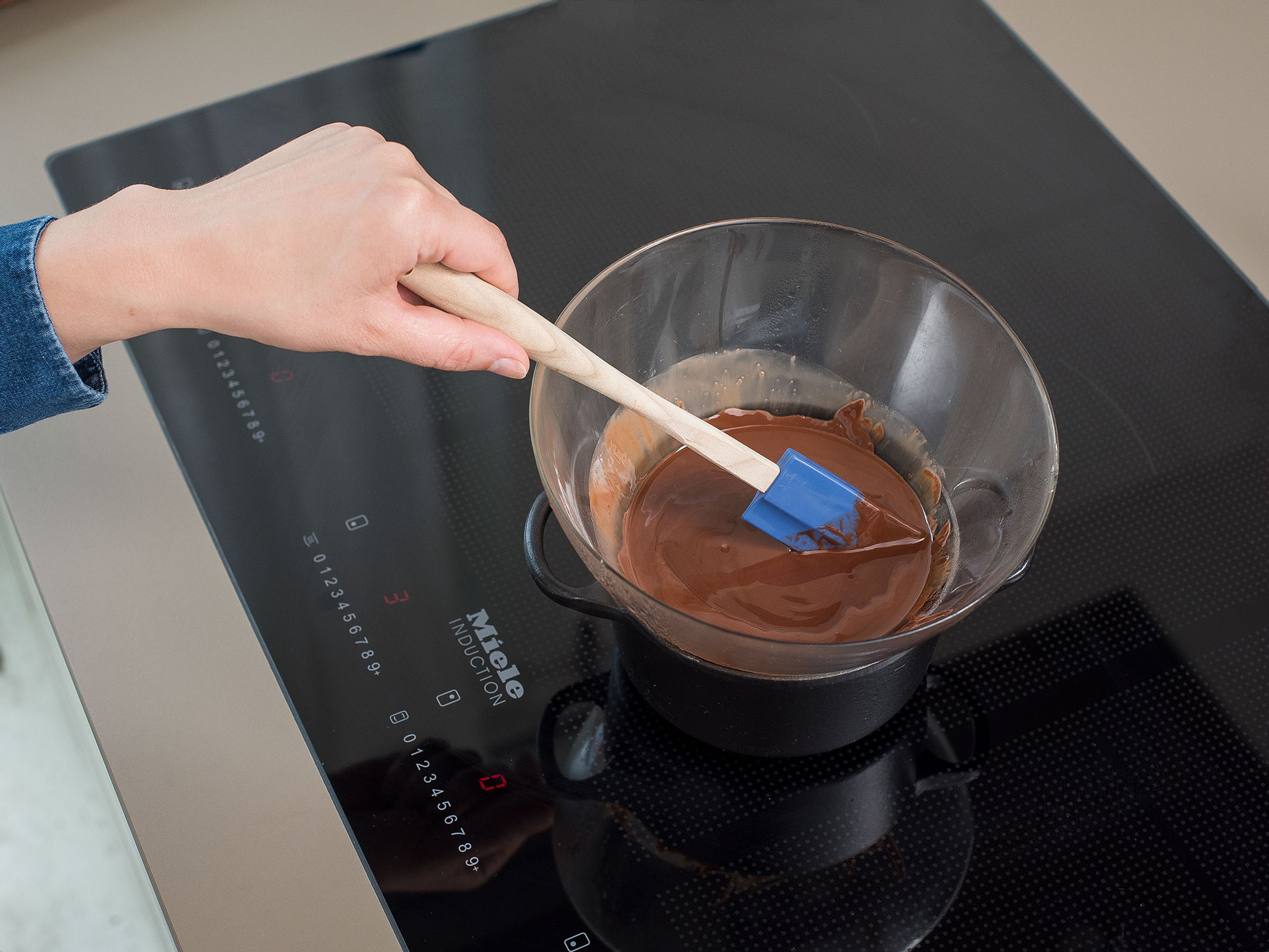 For the glaze, break some of the remaining chocolate into pieces and melt together with the coconut oil in a heatproof bowl set over a pot of simmering water. Stir gently until melted. Remove from the heat and let cool down slightly to thicken.