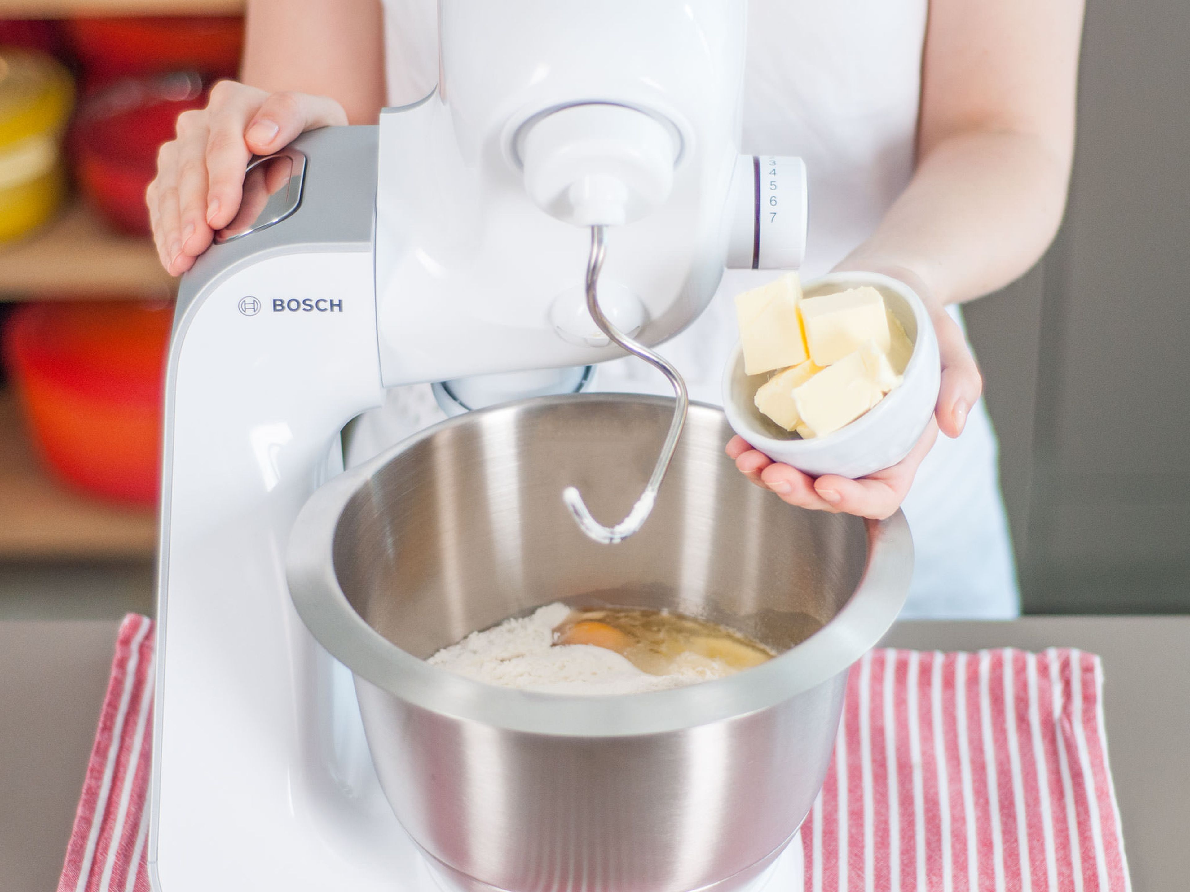 Eier und Salz sowie Teile von Mehl, Zucker und Butter hinzufügen und zu einem Teig verarbeiten. Abdecken und für ca. 45 Min., oder bis der Teig beinahe zur doppelten Größe angewachsen ist, gehen lassen.