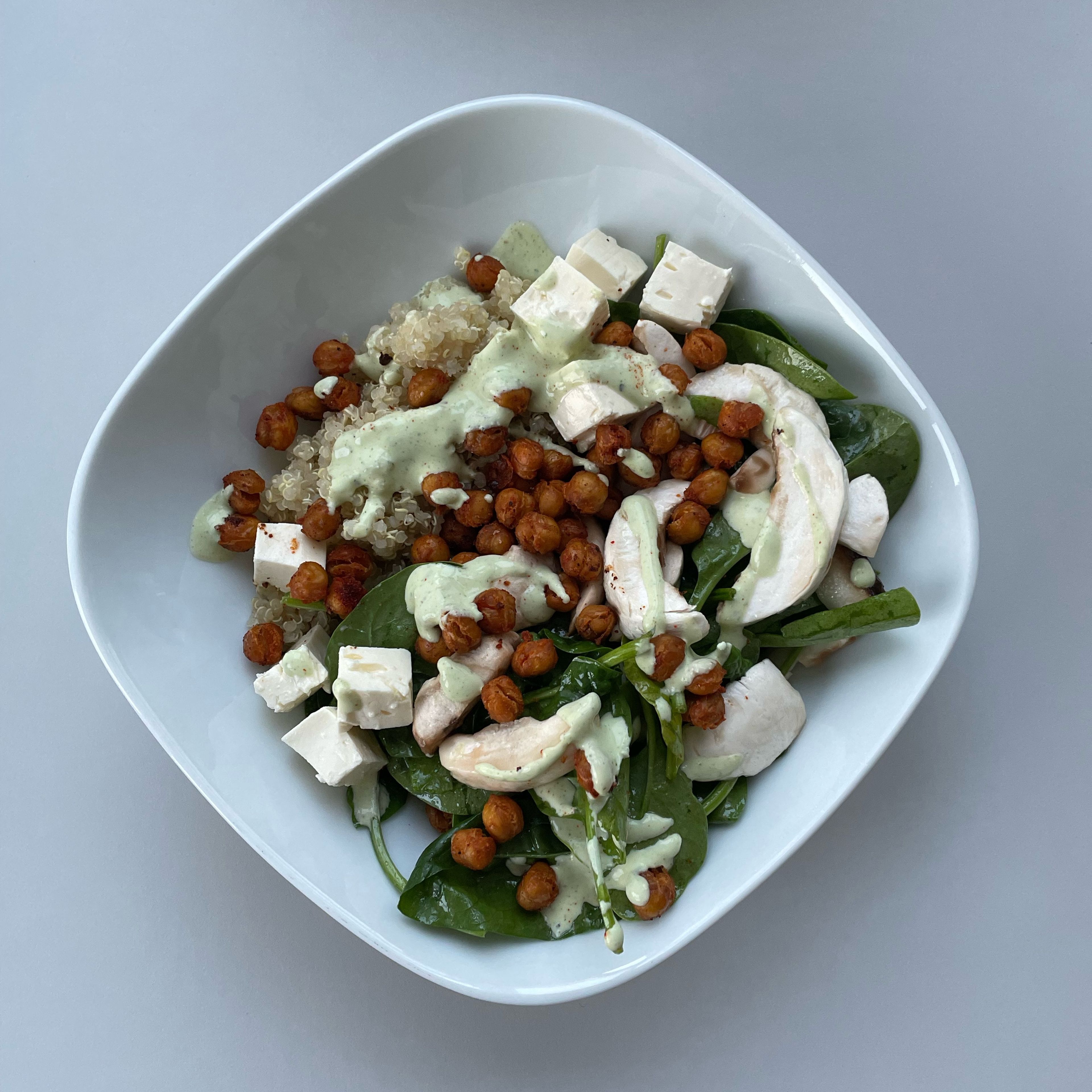 Add the cooked quinoa and spinach & mushroom salad to a bowl. Add the feta cheese you had previously set aside cut in cubes and the crunchy chickpeas. Top it with the lemony feta dressing sauce and enjoy!