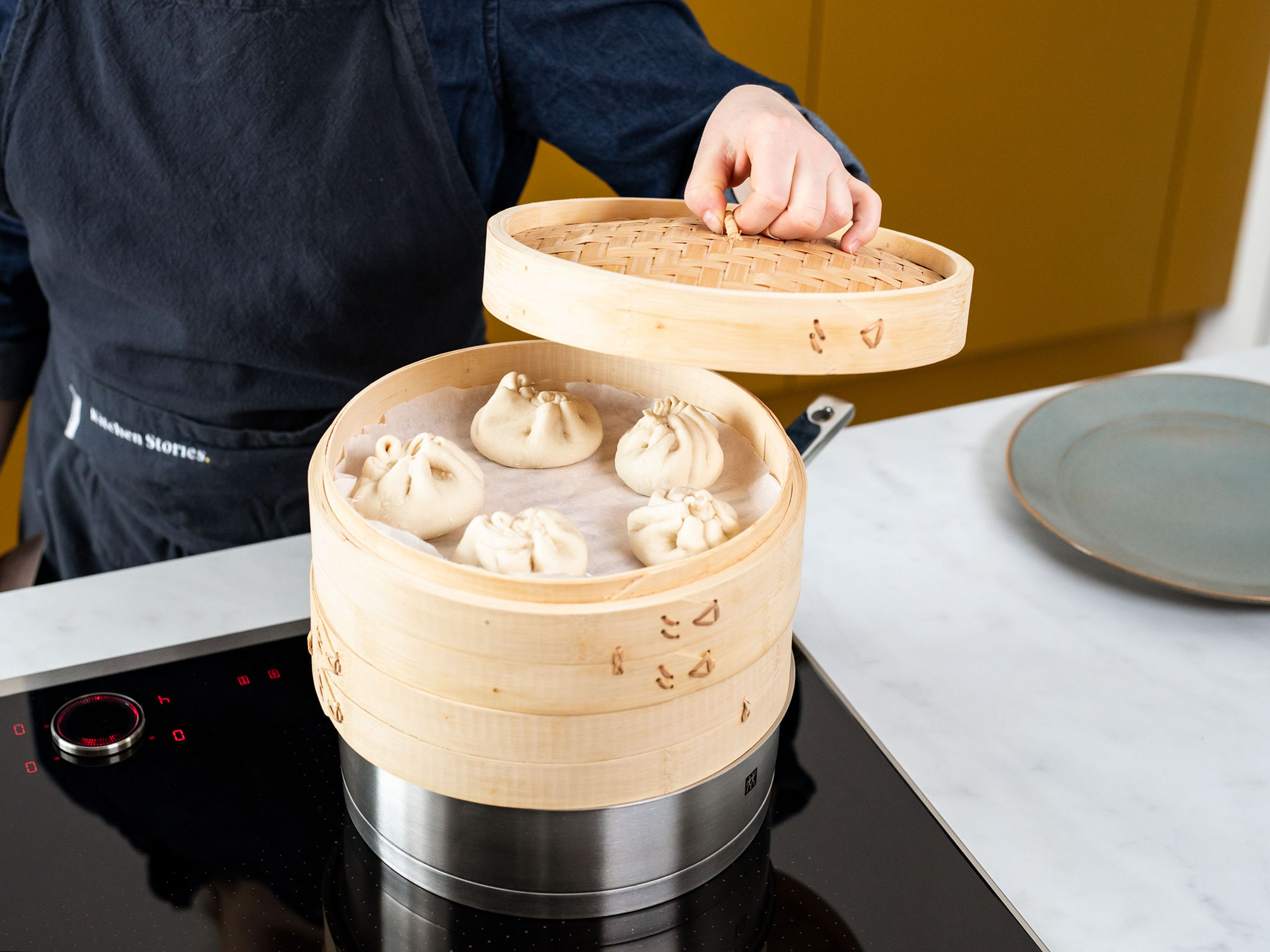 Set up a bamboo steamer lined with parchment paper over a pan of simmering water. Add bao buns to steamer and steam for approx. 12 min. over medium-low heat. Turn off heat and let bao buns sit in the steamer for another 5 min. Garnish with scallions and serve with sweet soy sauce. Enjoy!