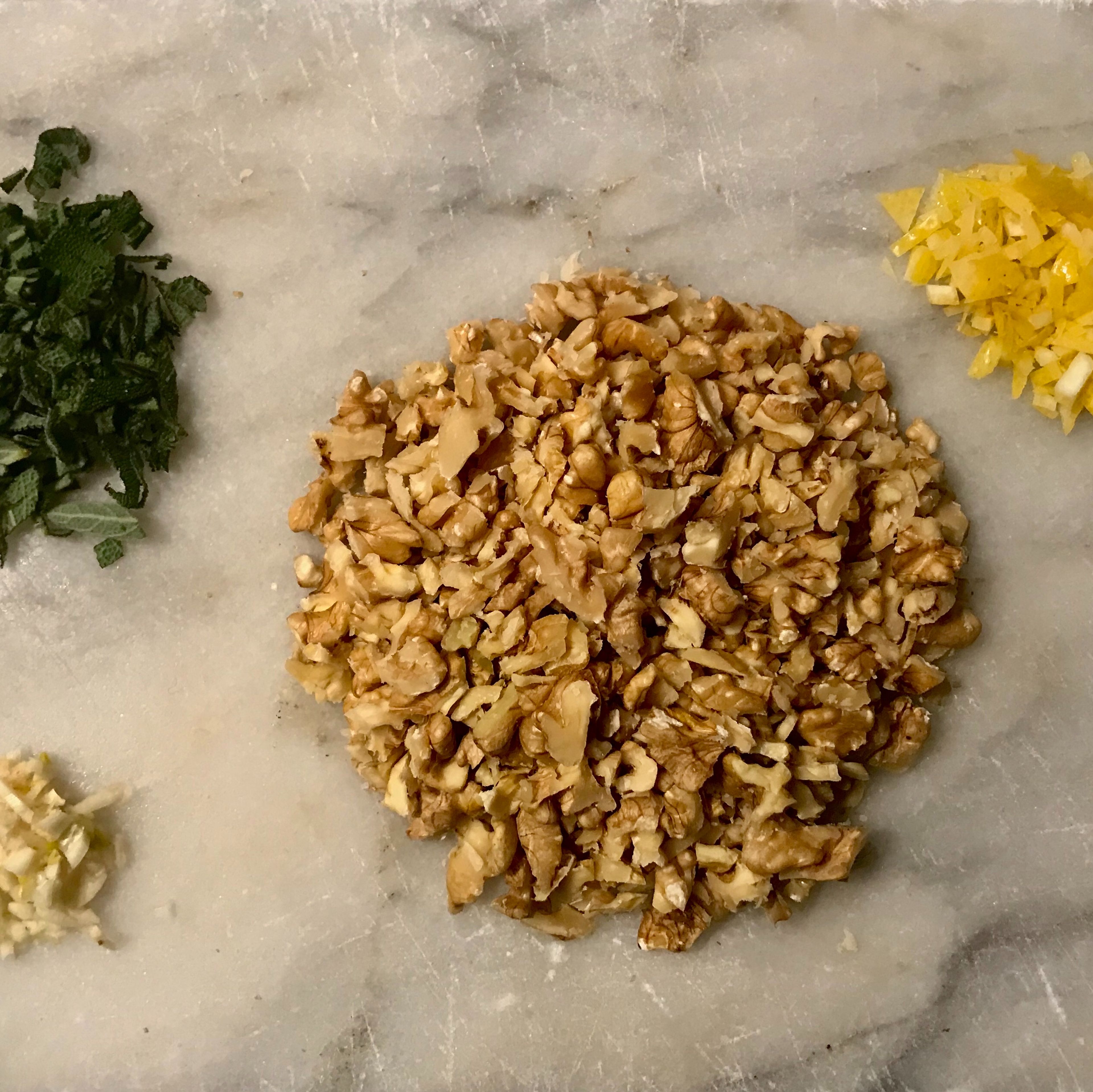Chop the walnuts, garlic clove and sage leafs. Zest the lemon and cut the zest into thin slices.