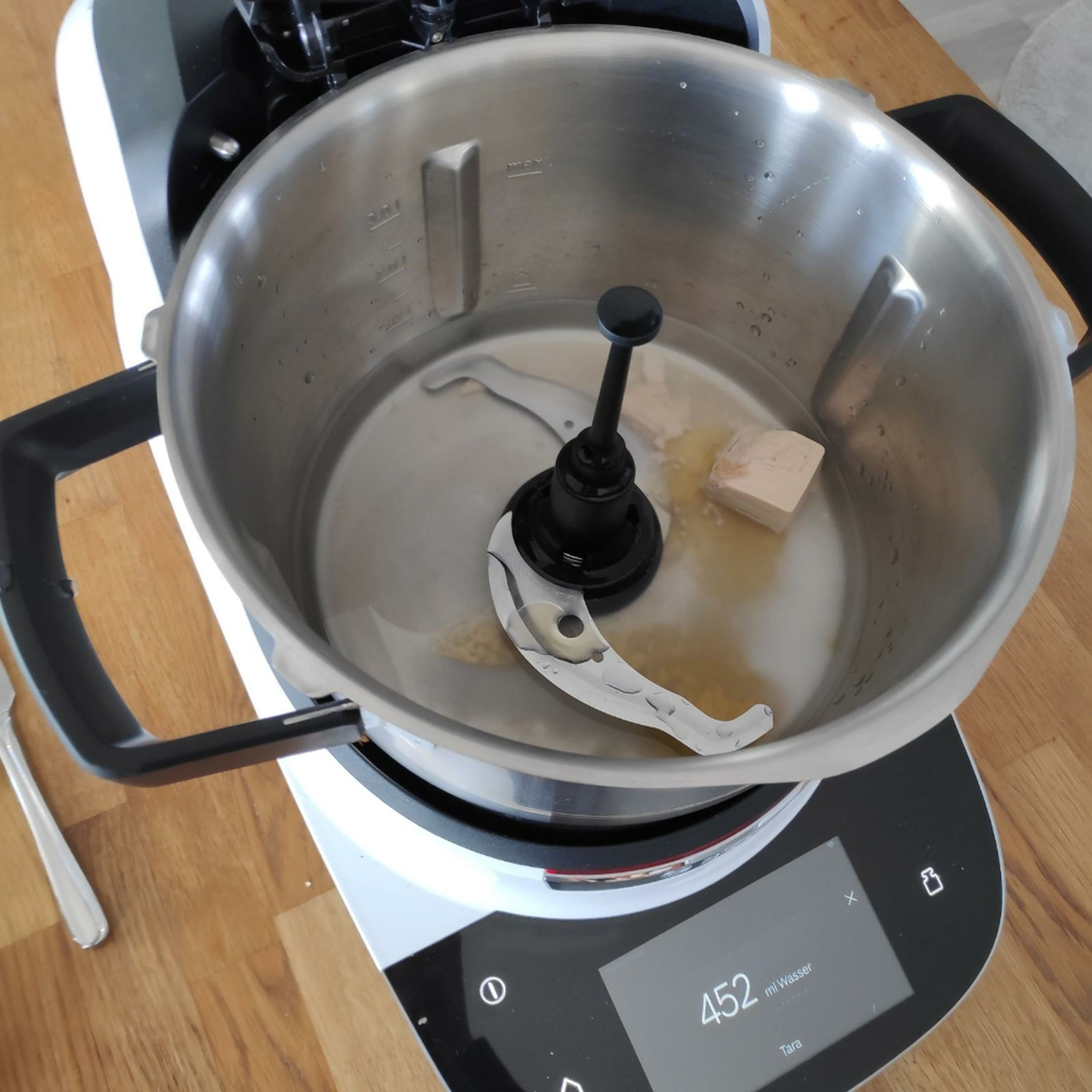 Universalmesser einsetzen. ½ Würfel Hefe, Honig, Salz und Wasser in den Cookit geben und bei geschlossenem Deckel und eingesetztem Messbecher auf Stufe 6 und 37°C für 2 Minuten verrühren (Universalmesser | Stufe 6 | 37°C | 2 Min.).