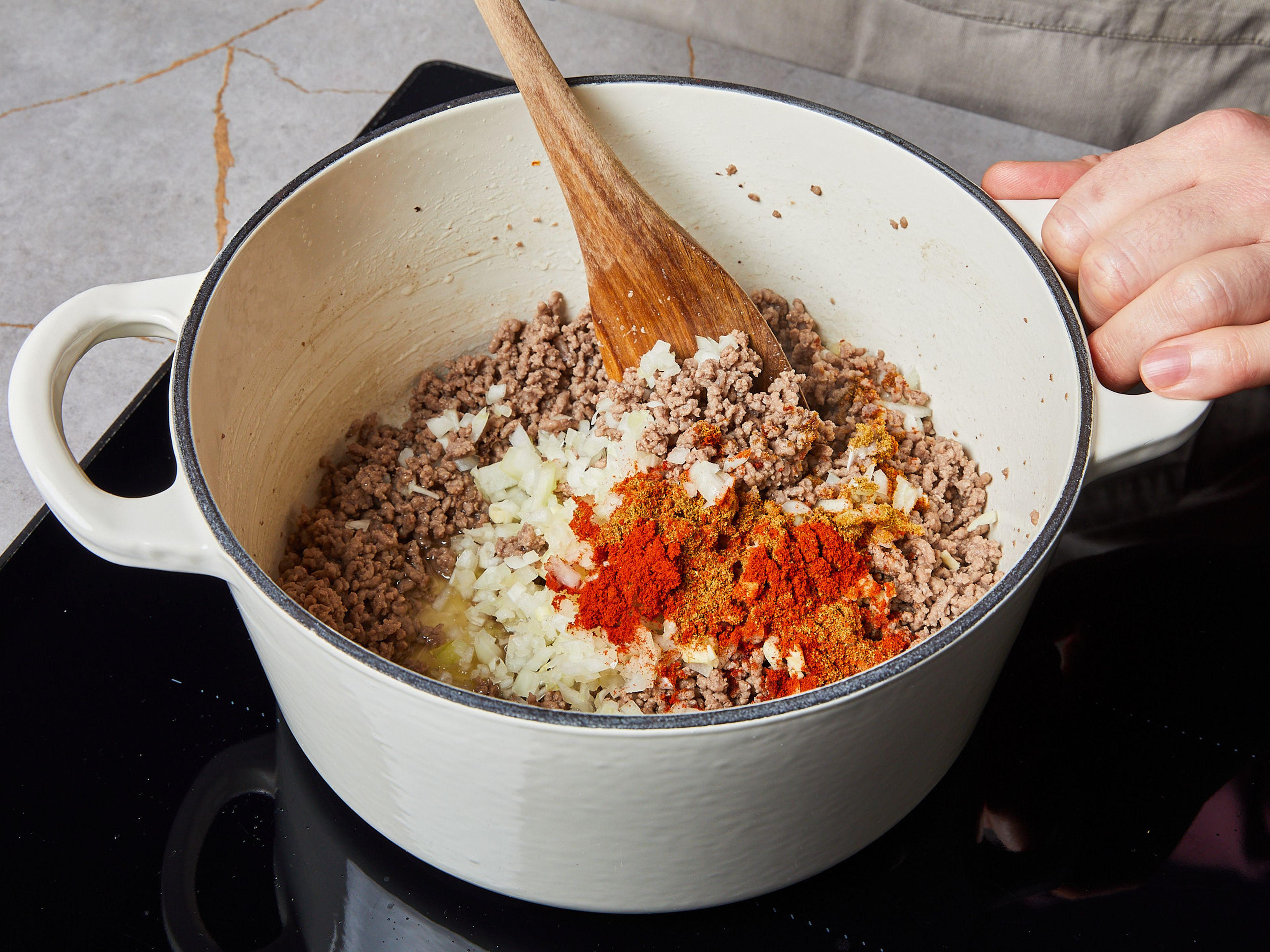 Heat up some vegetable oil in a large saucepan over medium heat. Add ground beef and sauté for approx. 2–3 min. until browned. Then add cumin, paprika powder, chili, garlic, and onion. Avoid stirring too much to ensure that the meat stays flavorful.