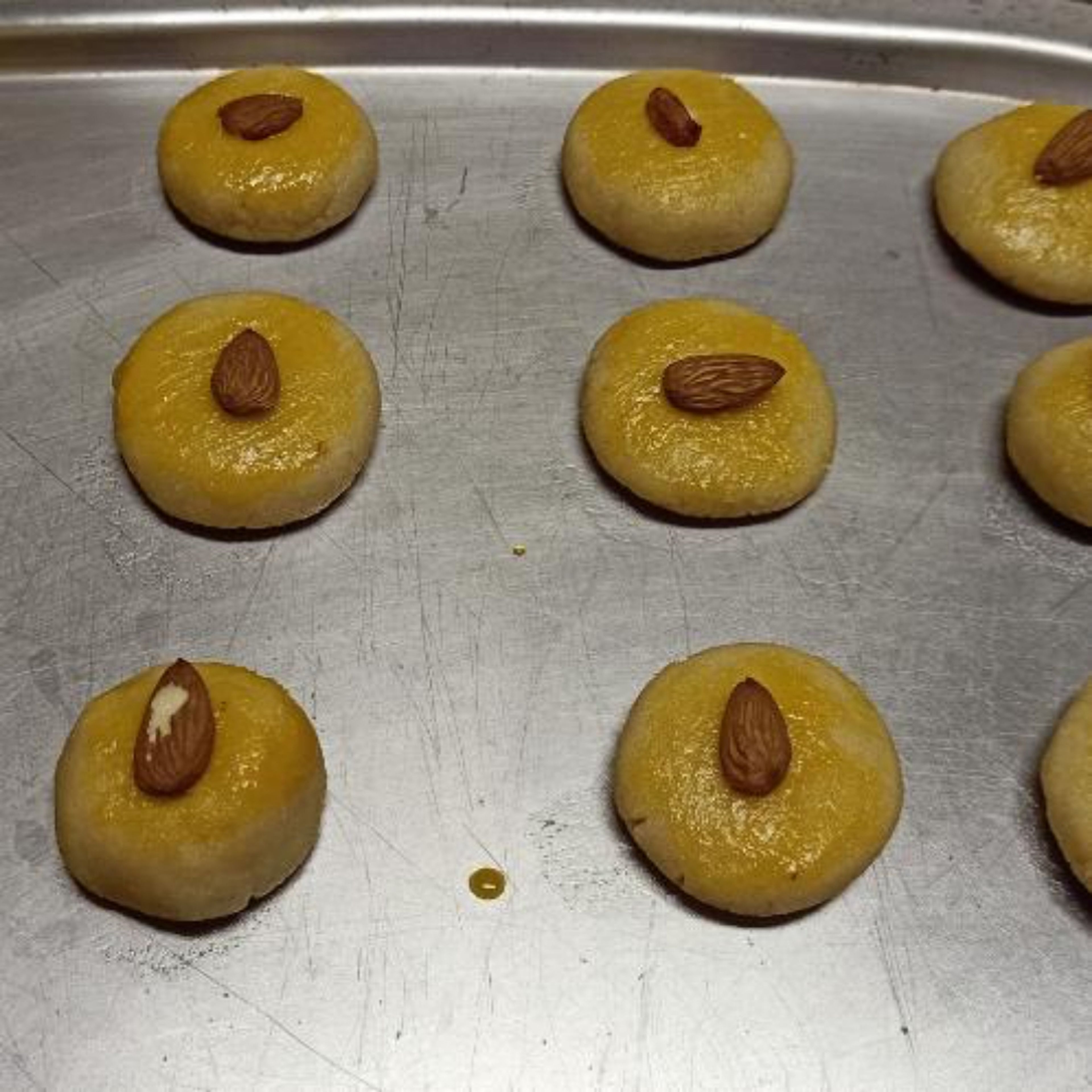 Beat the egg yolk in a small bowl. Using a pastry brush, lightly glaze the top of the cookie balls with the egg yolk.