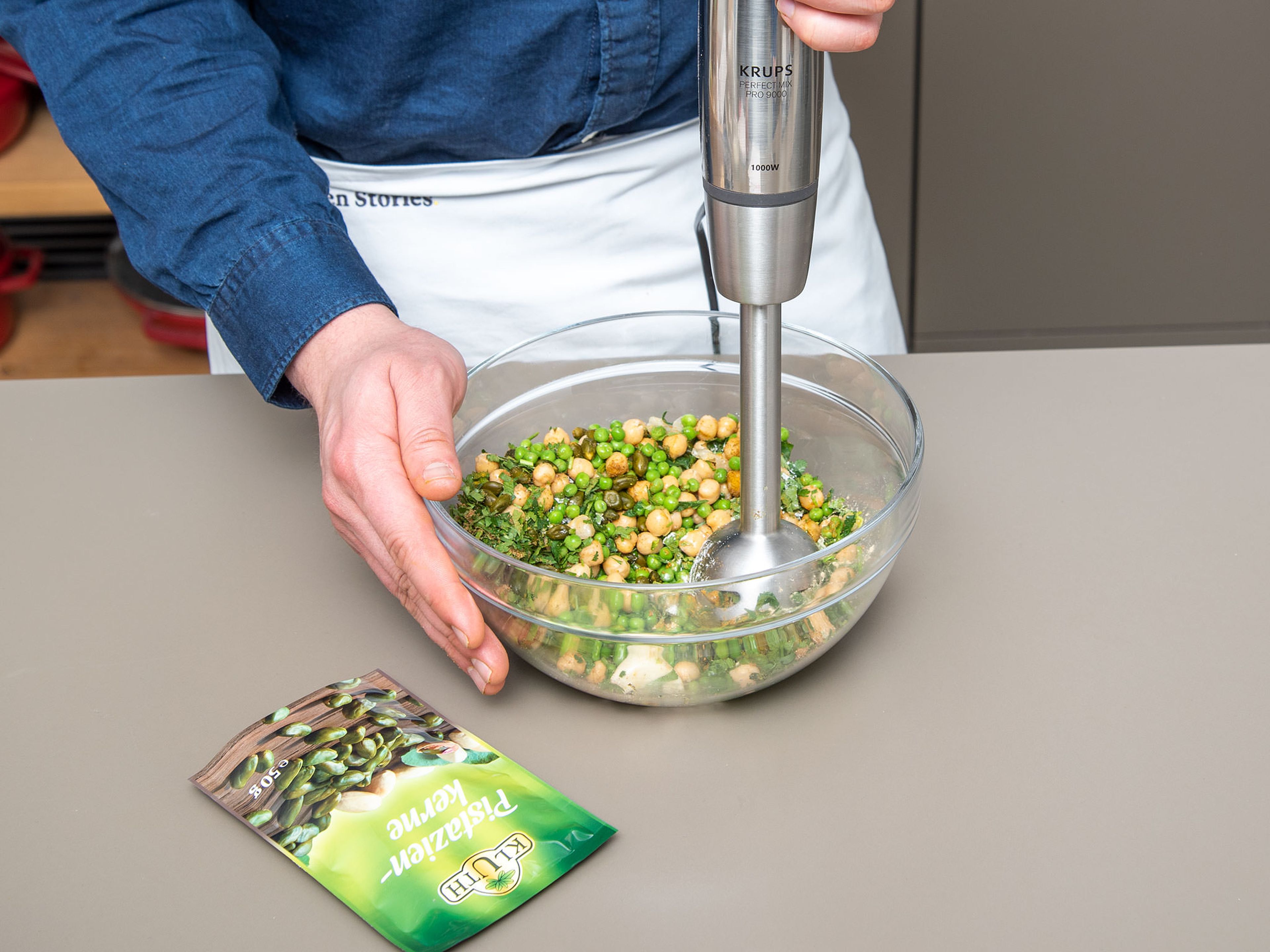 Add chickpeas, peas, garlic, half the chopped scallions, a pinch of chopped parsley, cilantro, half the mint, caraway, ras el hanout, lime zest, pistachios, vegetable oil, salt, and pepper to a large bowl. Purée with an immersion blender until well combined.