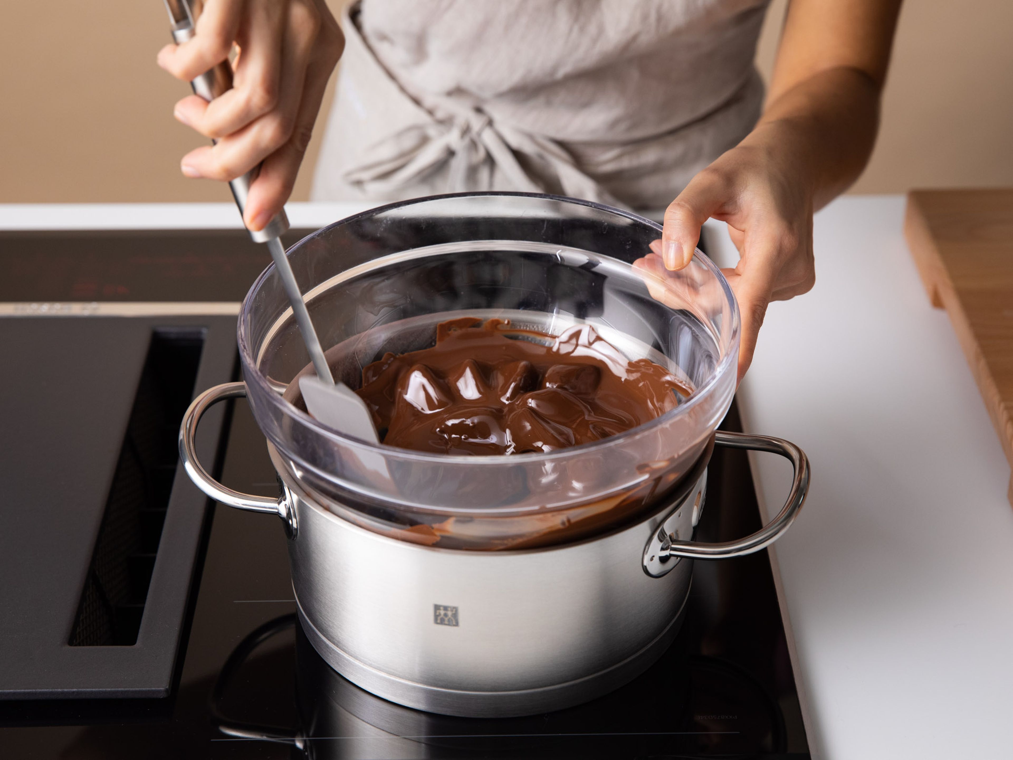 Schokolade in einer hitzebeständigen Schüssel über siedendem Wasser schmelzen lassen.