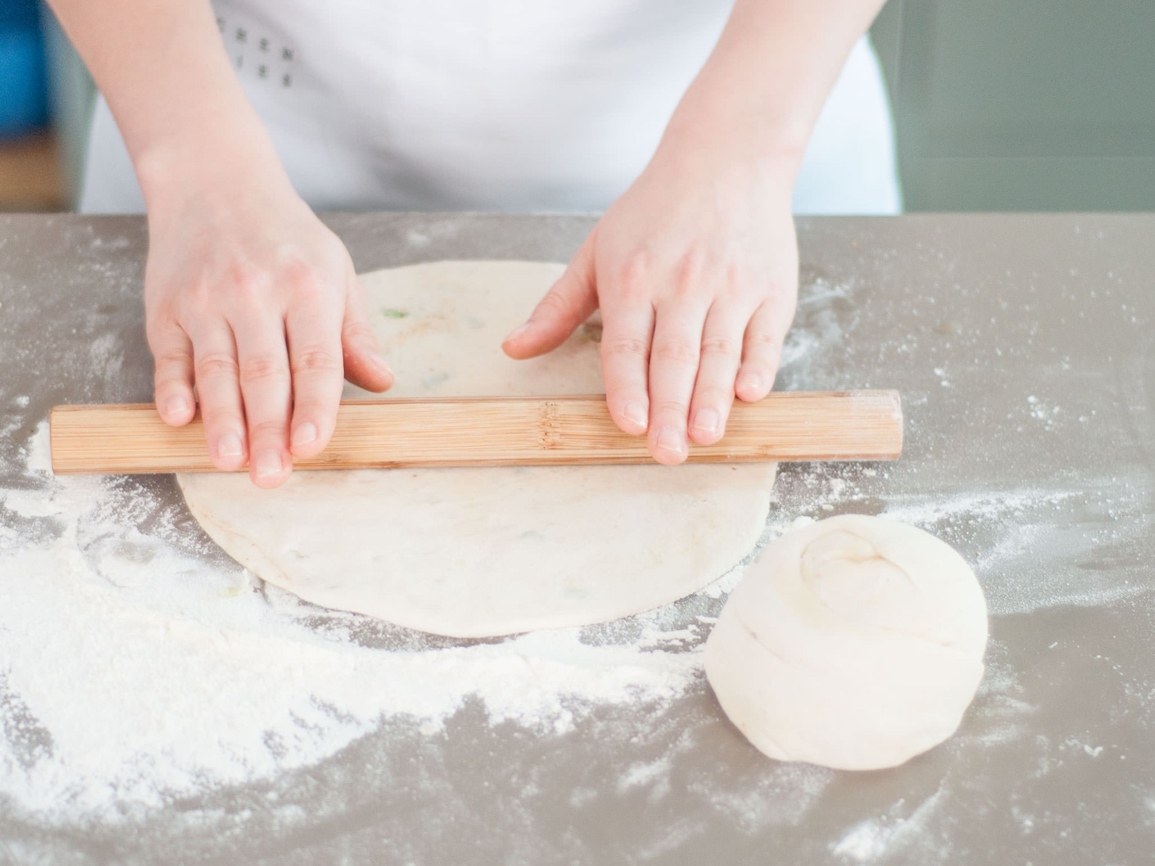 Tightly roll the dough into a ball from one of the short ends; press down with the palm of your hand. Cover with plastic wrap and let rest for approx. 10 – 15 min. Remove plastic wrap and roll into a large, flat pancake, approx. size of the frying pan.