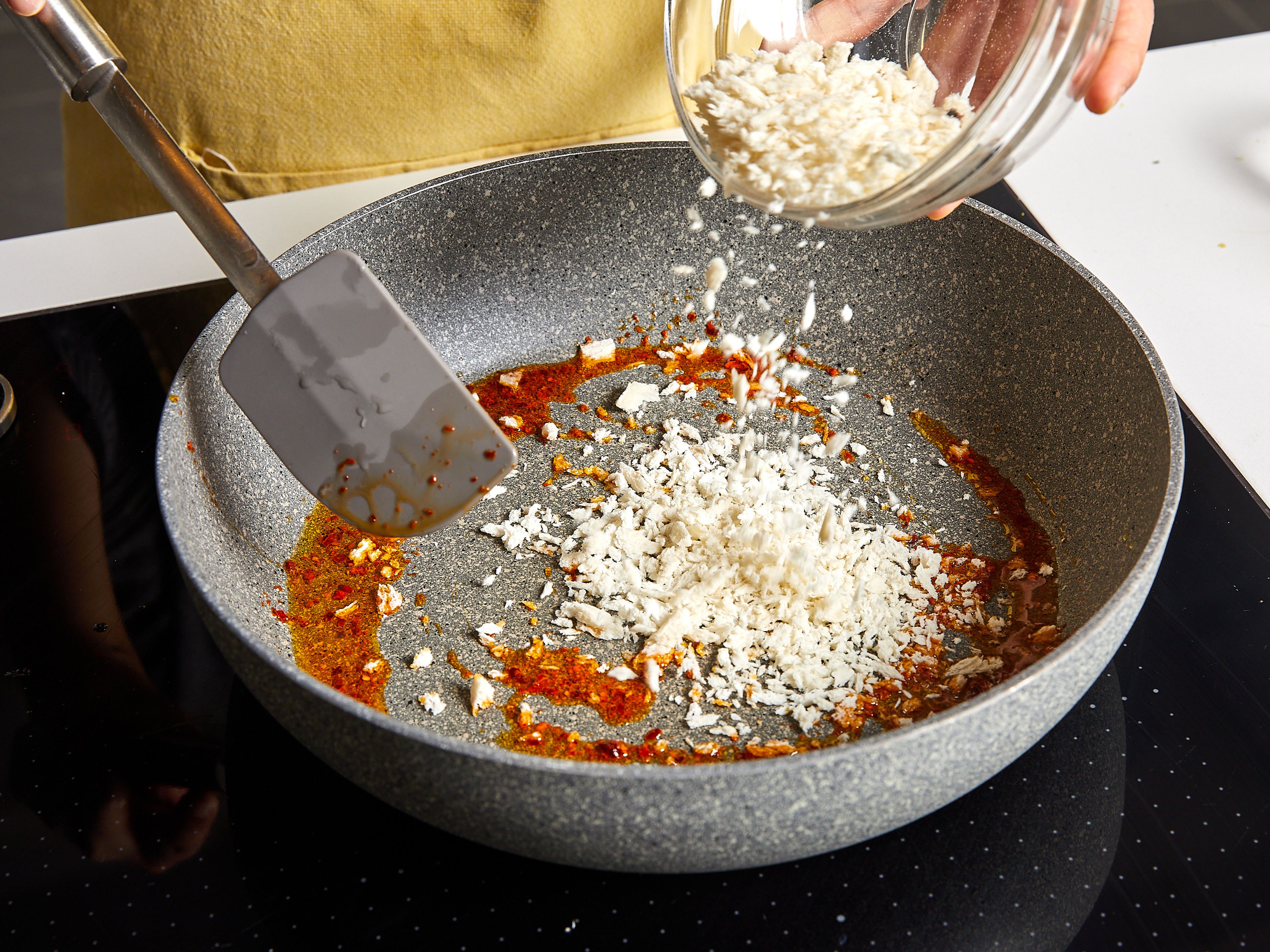 Einen großen Topf mit Wasser zum Kochen bringen und großzügig salzen. Nudeln hinzugeben und ca. 2 Min. kürzer als in der Packungsbeilage angegeben kochen. Nach der Kochzeit etwa 250 ml Nudelwasser auffangen. In der Zwischenzeit in einer großen Pfanne einen Teil des Olivenöls bei mittlerer Hitze erhitzen und die Chiliflocken hinzufügen. Ca. 1 Min. braten, bis das Öl rot geworden ist. Panko-Paniermehl hinzufügen und ca. 3 Min. goldbraun anbraten. Anschließend Panko herausnehmen und beiseitestellen.