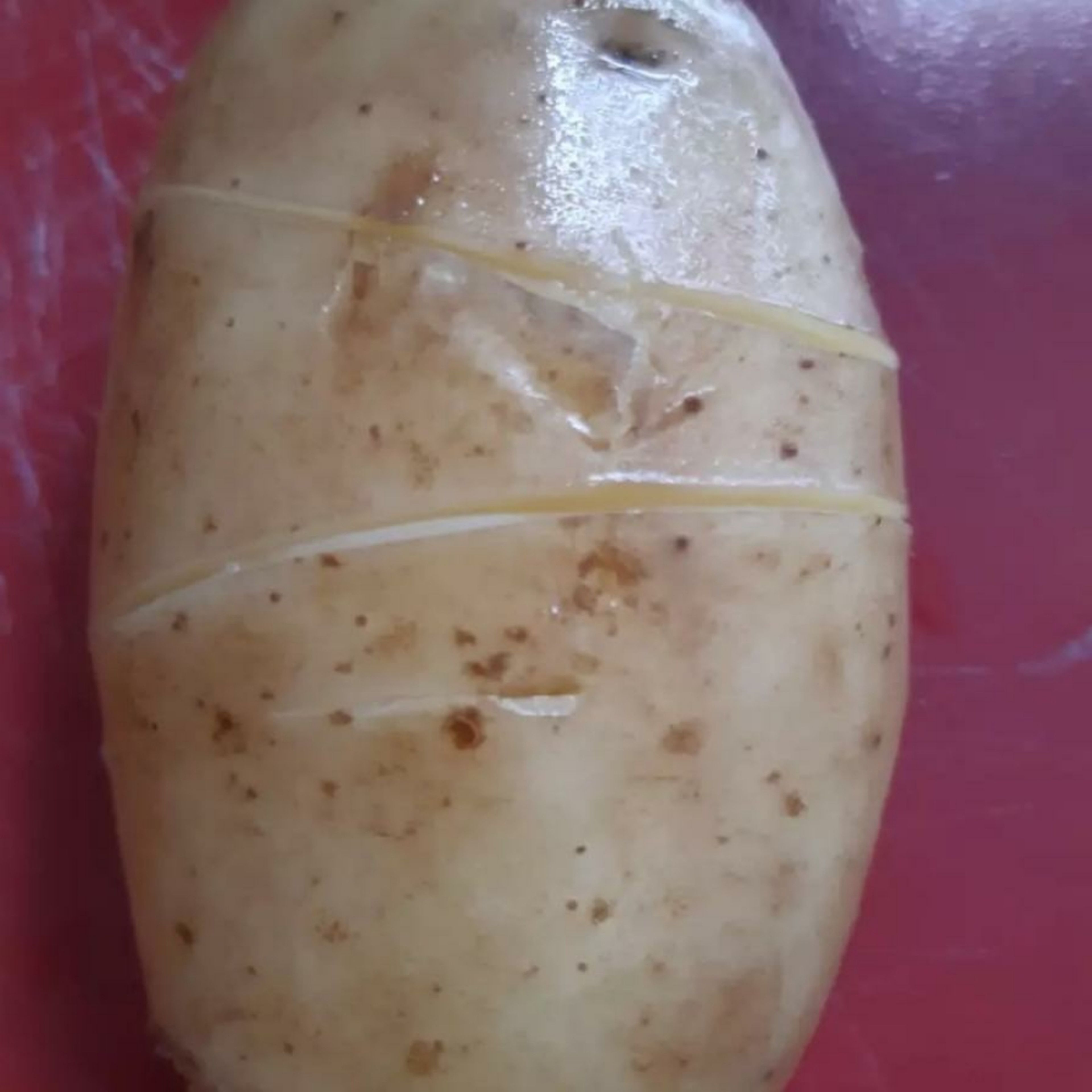 Kartoffeln waschen. Ich ritze die die Kartoffeln um die Schale herum ein, um sie nach dem Kochen leichter schälen zu können (s. Foto). Kartoffeln in Wasser zum Kochen bringen. Die Kartoffeln abkühlen lassen. Eventuell in kaltes Wasser legen.