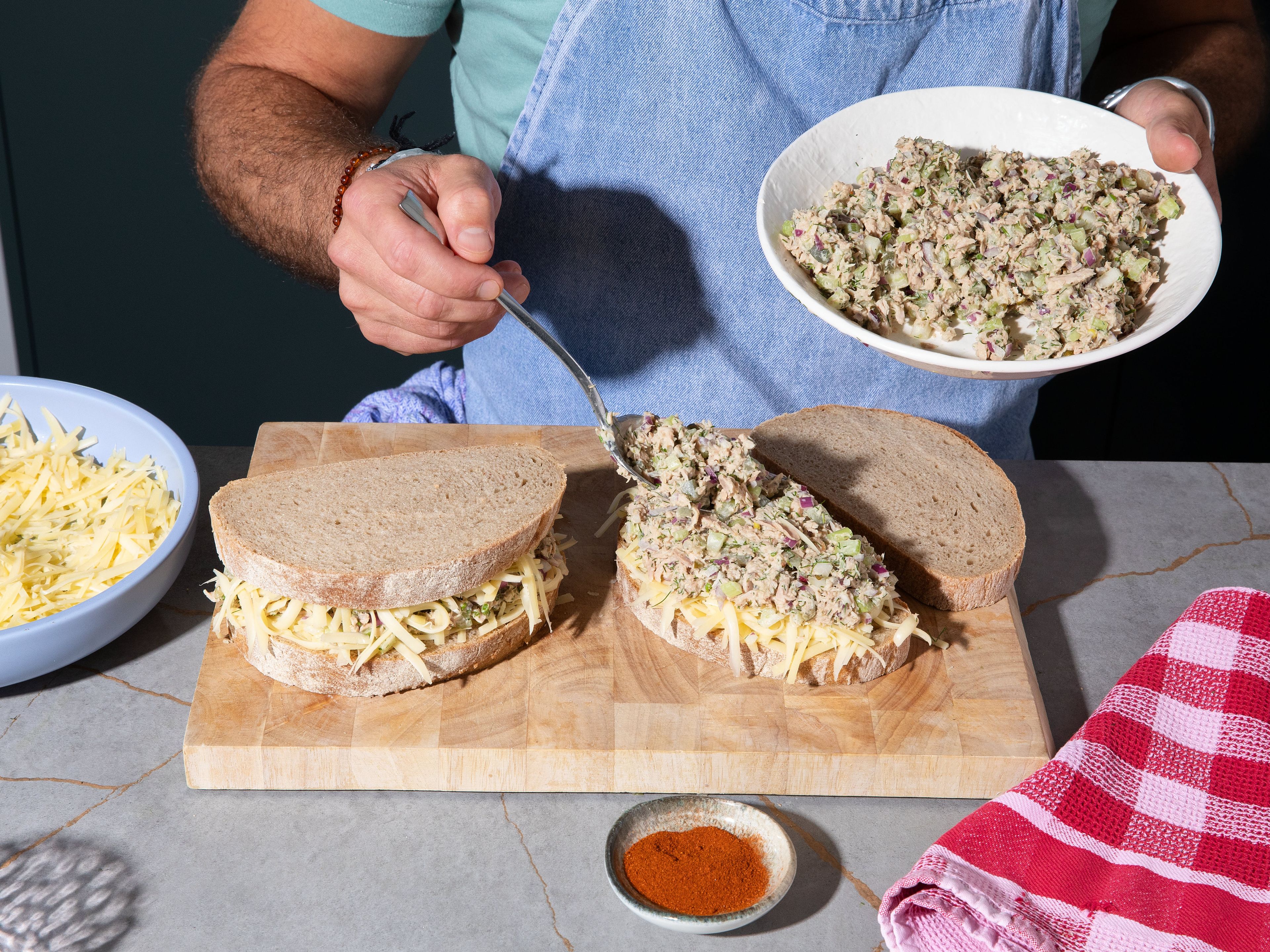 Mix mayonnaise with smoked paprika. Assemble the sandwiches by layering cheese on 2 bread slices. Spread tuna paste flat and evenly on each slice. Add rest of cheese on top of tuna salad. Cover with remaining 2 slices of bread. Press to firm sandwiches up.