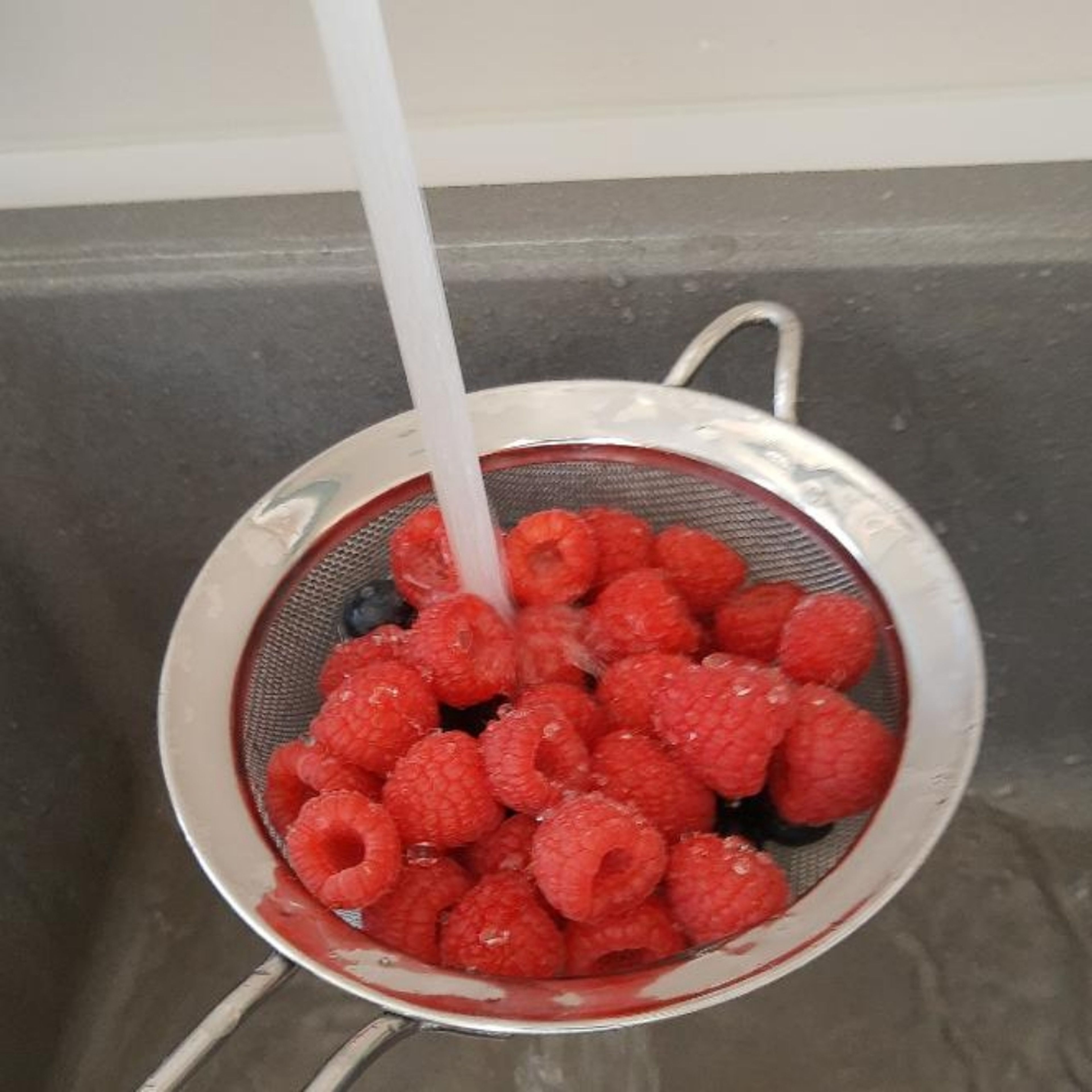 Eine Tasse frische Beeren gründlich waschen.