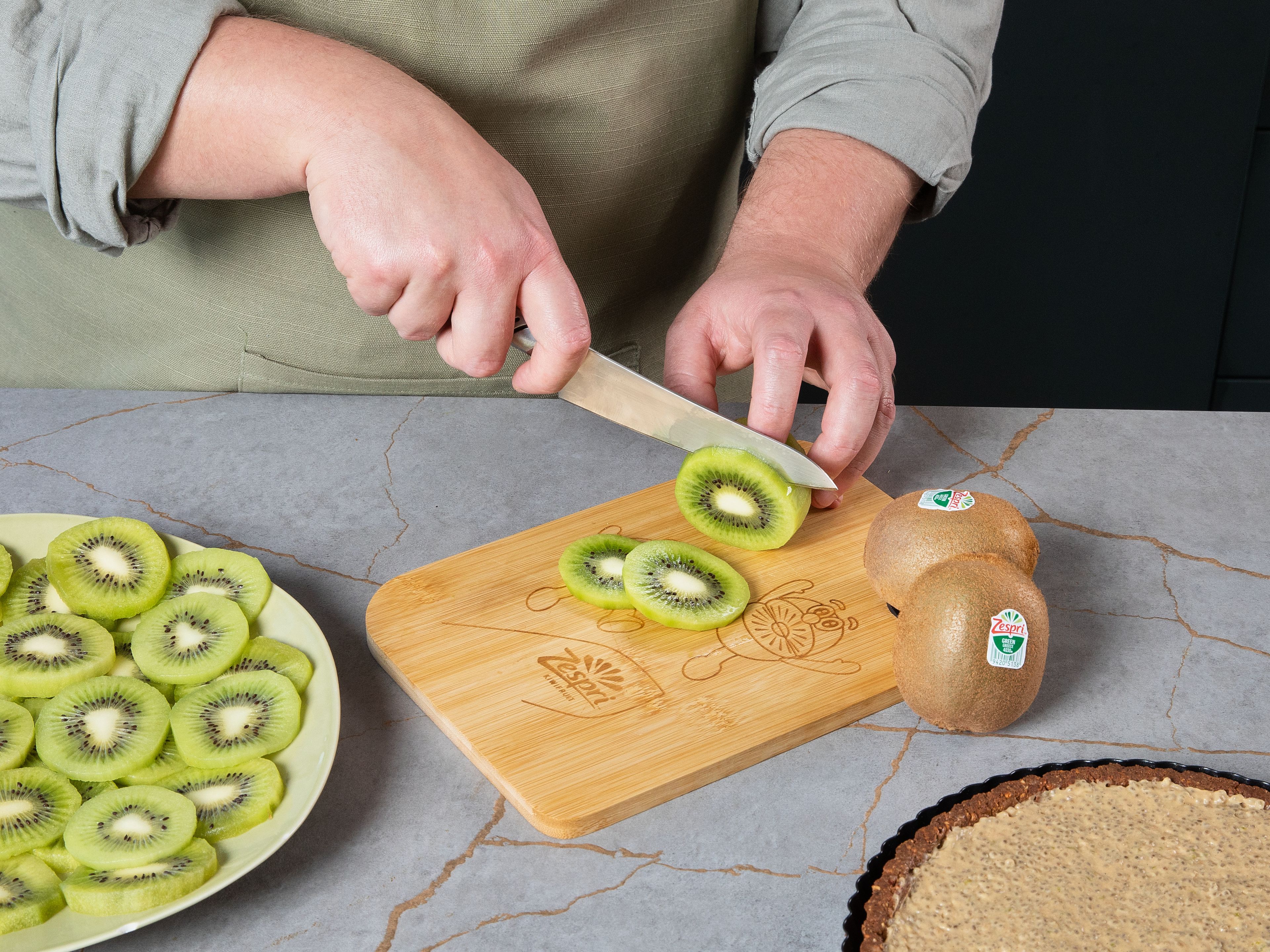 Den ausgekühlten Tarteboden dünn mit Mandelmus bestreichen. Die Joghurt-Chia-Füllung darauf verteilen und glatt streichen. Für ca. 2 Std. kalt stellen, bis die Füllung fest geworden ist. Zespri™ Green Kiwis schälen, in dünne Scheiben schneiden und spiralförmig auf der Tarte anrichten.