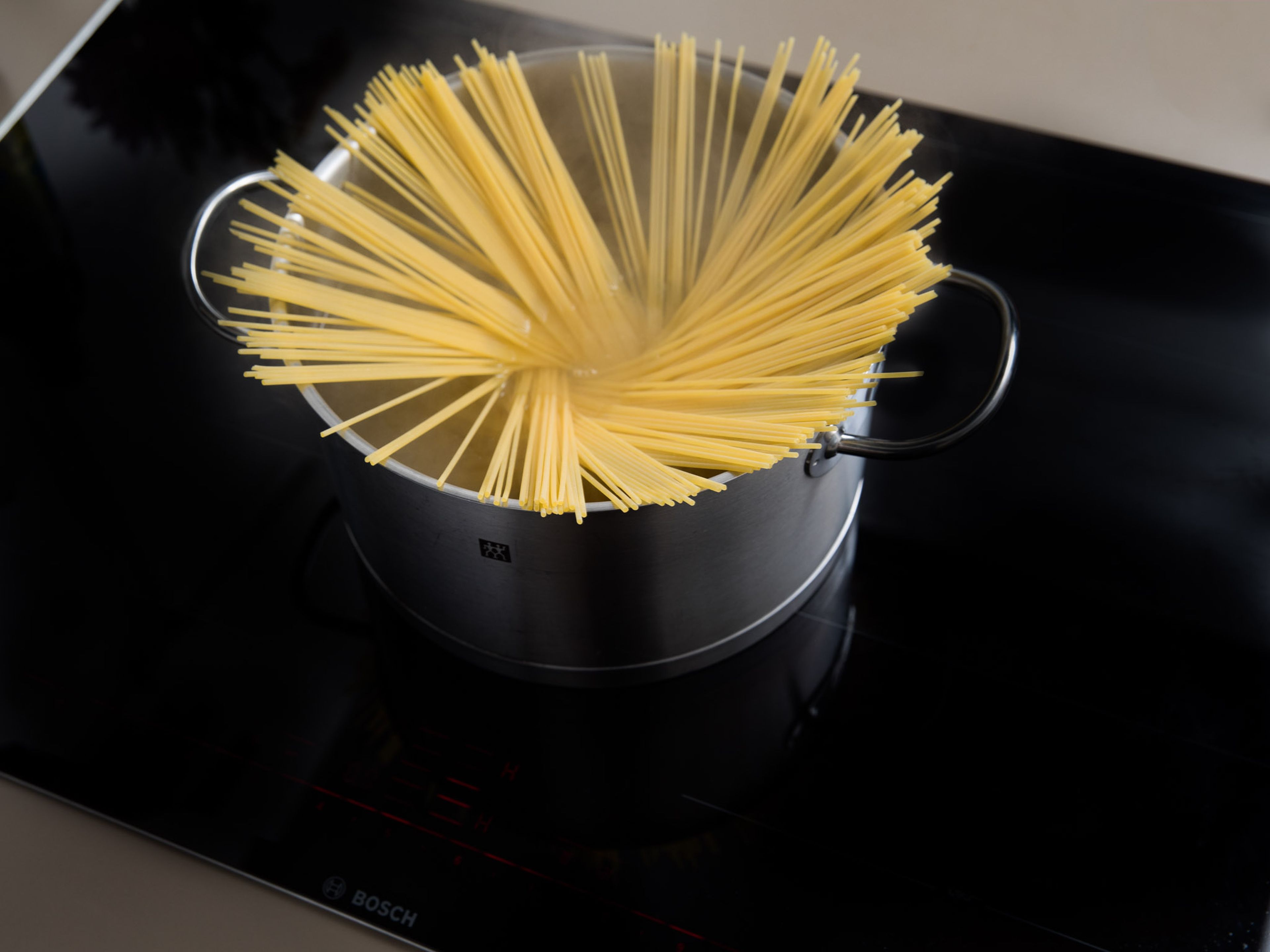 Gesalzenes Wasser in einem großen Topf zum Kochen bringen. Spaghetti ca. 7 - 9 Min. kochen, oder bis sie al dente sind. Ca. 100 ml des Kochwassers auffangen und beiseitestellen. Spaghetti abgießen.