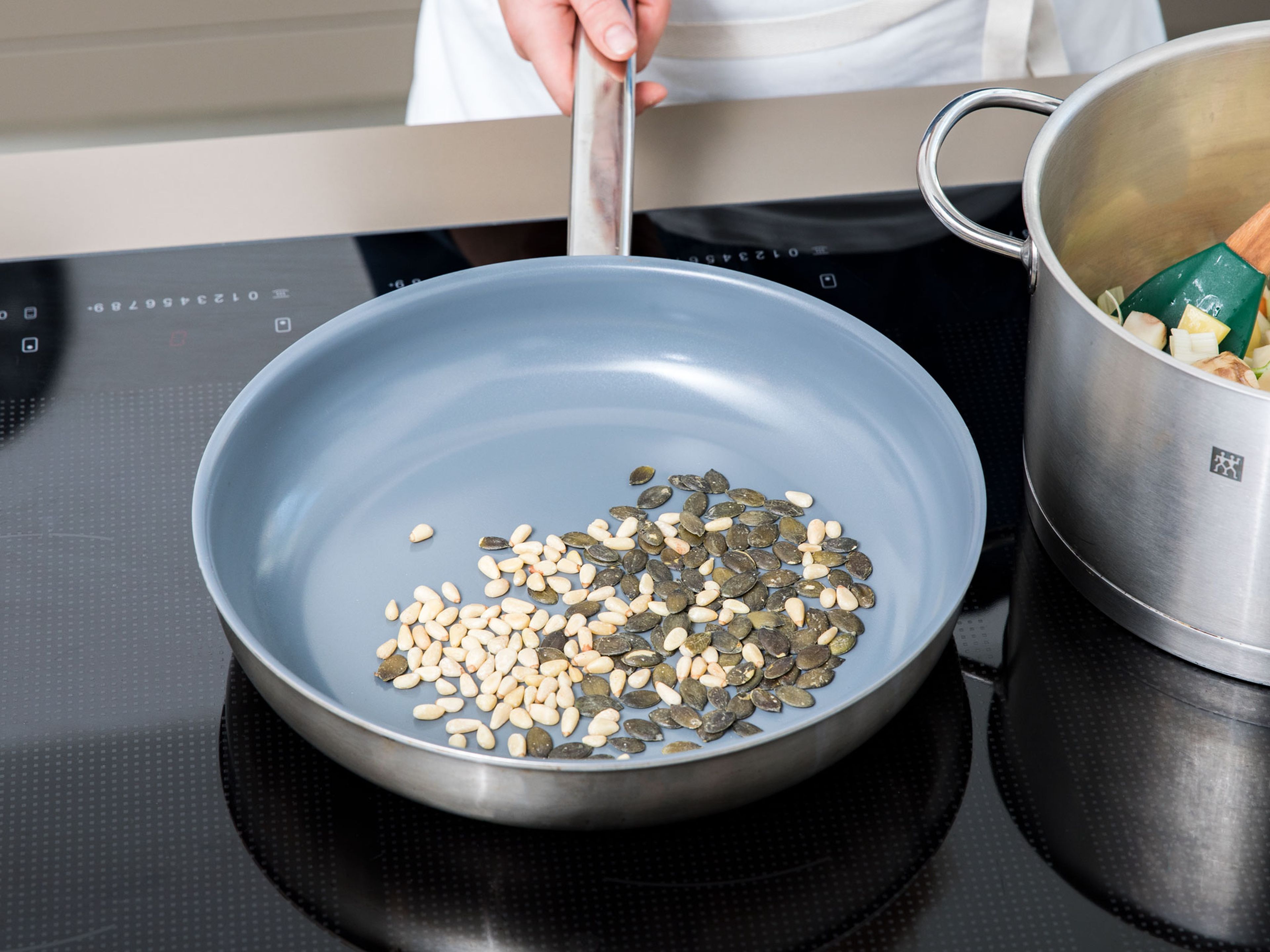 In the meantime, toast pine nuts and pumpkin seeds in a frying pan until they are nicely browned and fragrant. Remove the seeds from the pan and set aside.
