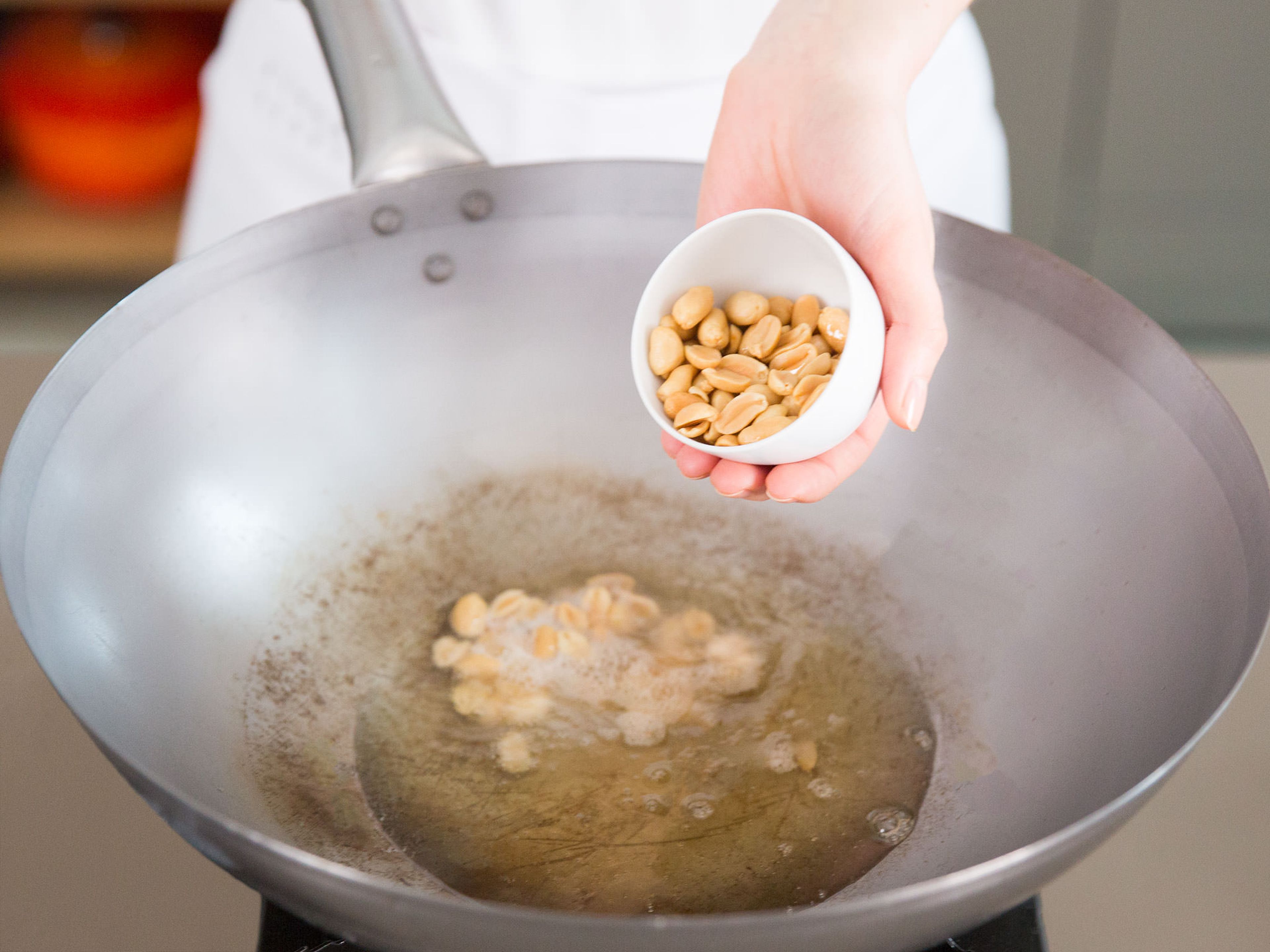 Add oil to a wok and fry peanuts on low heat for approx. 3 – 4 min. Remove from pan, drain on a layer of paper towels, and set aside.