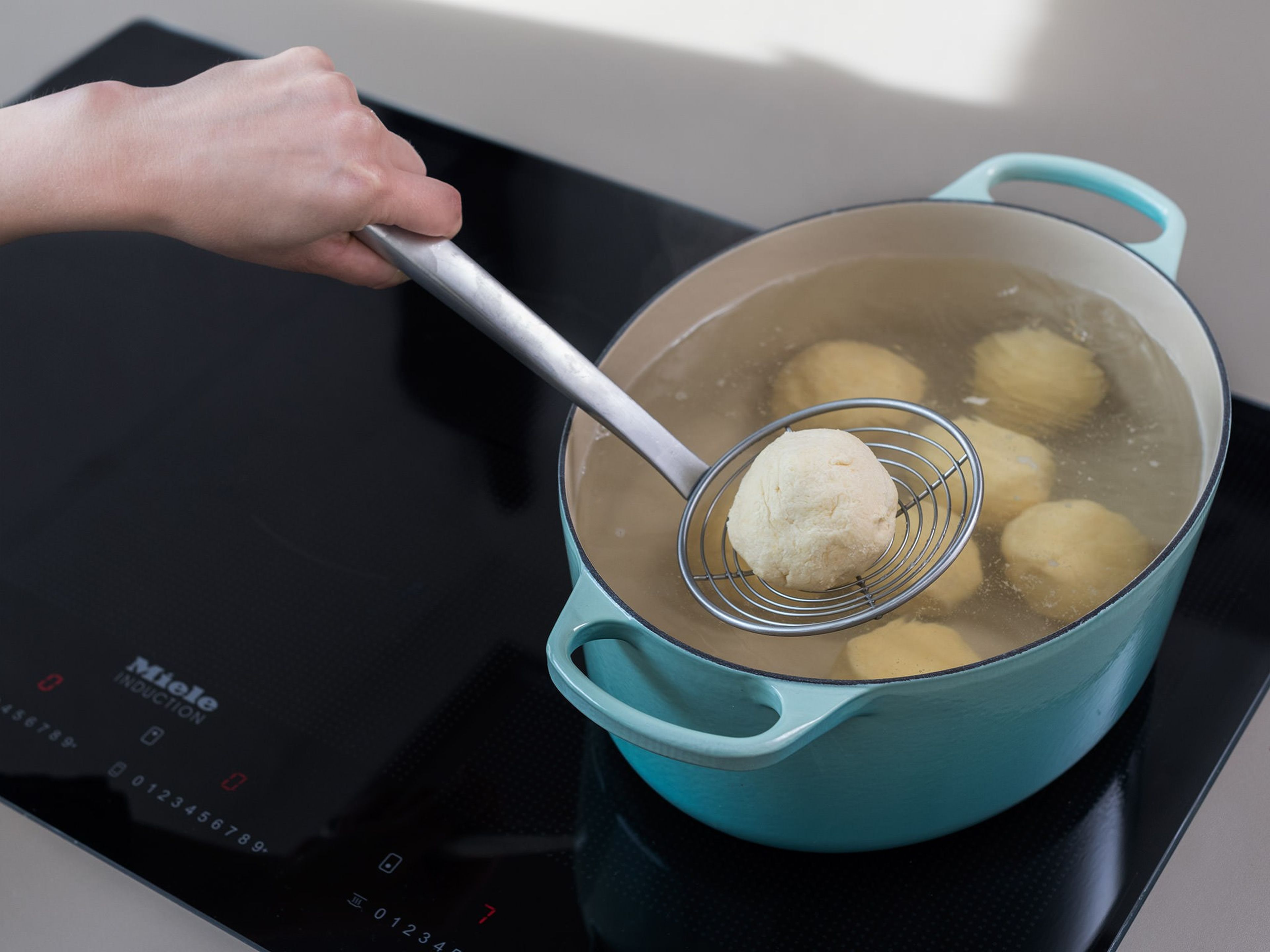 In a large saucepan, bring water to a boil. Cook the apricot dumplings for approx. 10 min. until they bob to the surface. Remove from the pot with a slotted spoon and allow to drain well.