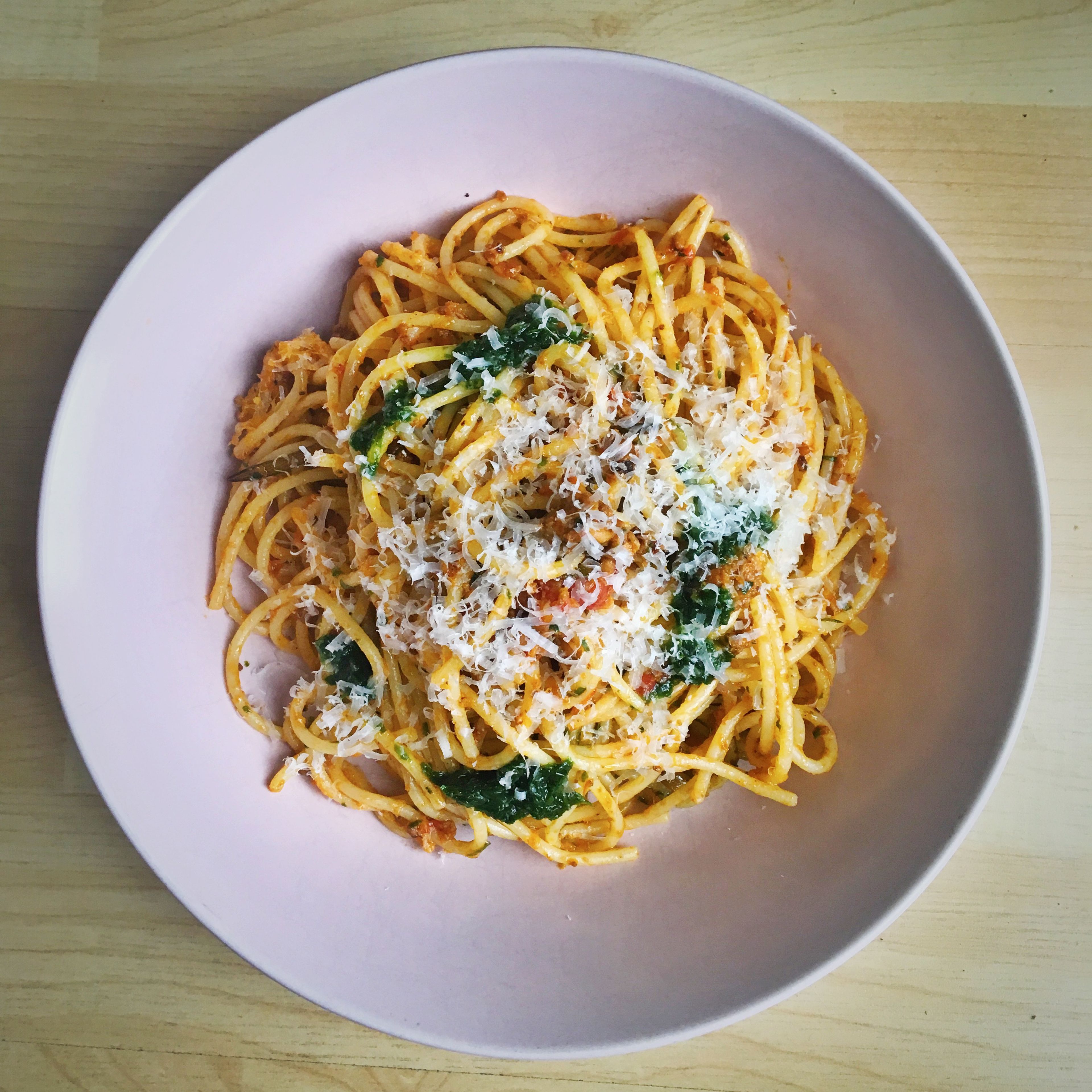Bolognesesoße mit Spaghetti servieren. Ich gebe gerne noch etwas Parmesan und, in diesem Fall, etwas Bärlauchpesto dazu. 🍝